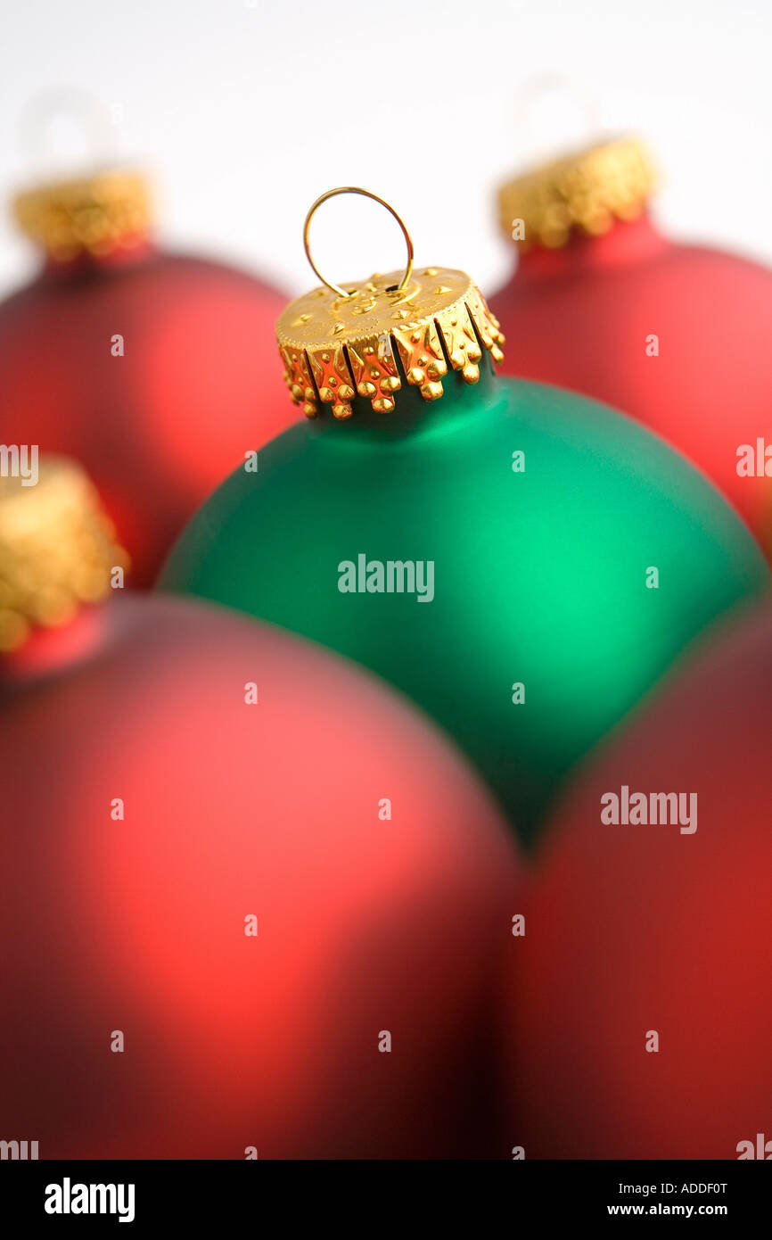 Nahaufnahme von einem grünen Weihnachtsbaum Birne Ornament unter roten Lampen auf weißem Hintergrund Studioportrait Stockfoto