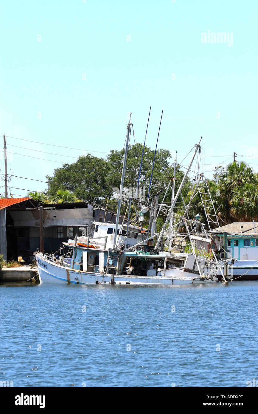 Eine große weiße Garnelen Boot sitzt auf dem Boden nach Untergang am Dock Stockfoto