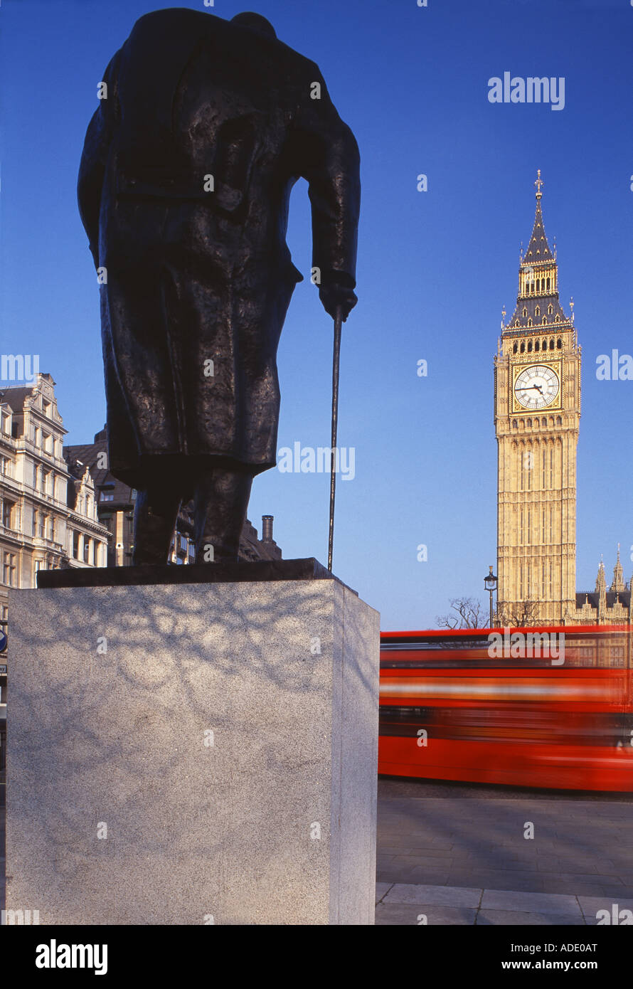 Die Statue von Sir Winston Churchill im Parliament Square mit Big Ben und ein Londoner Bus Westminster London UK Stockfoto