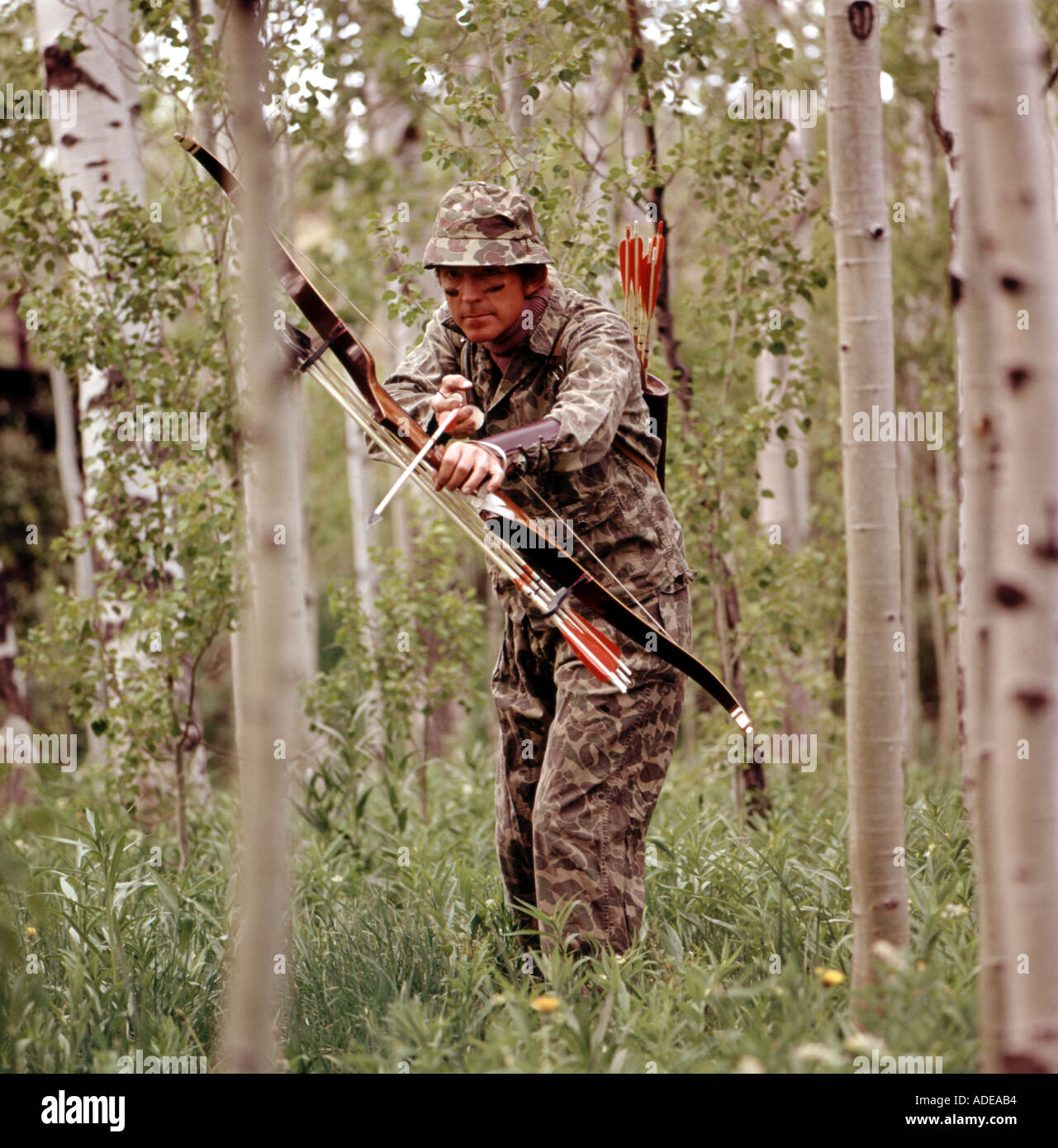 Bogen Jäger gekleidet in Camouflage-Outfit-Jagd in einer waldreichen Gegend Stockfoto