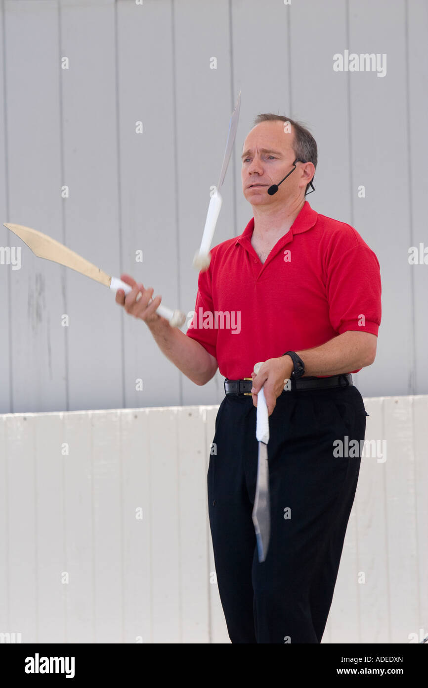 Männliche Jongleur vorgibt, unter dem Druck des Jonglierens mit Messern ängstlich schauen Stockfoto