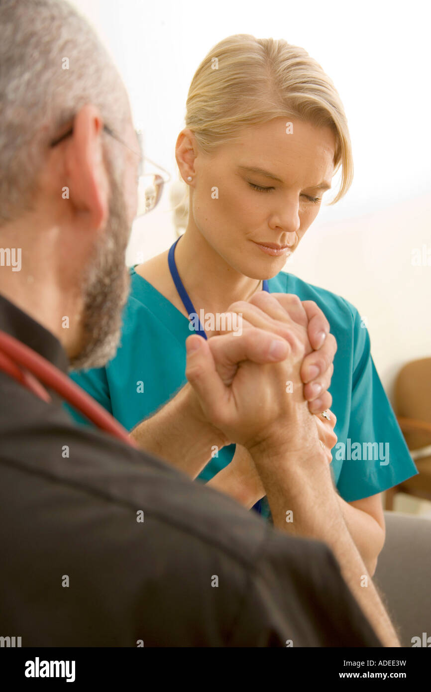 Krankenhaus Klerus betet mit Krankenschwester. Stockfoto