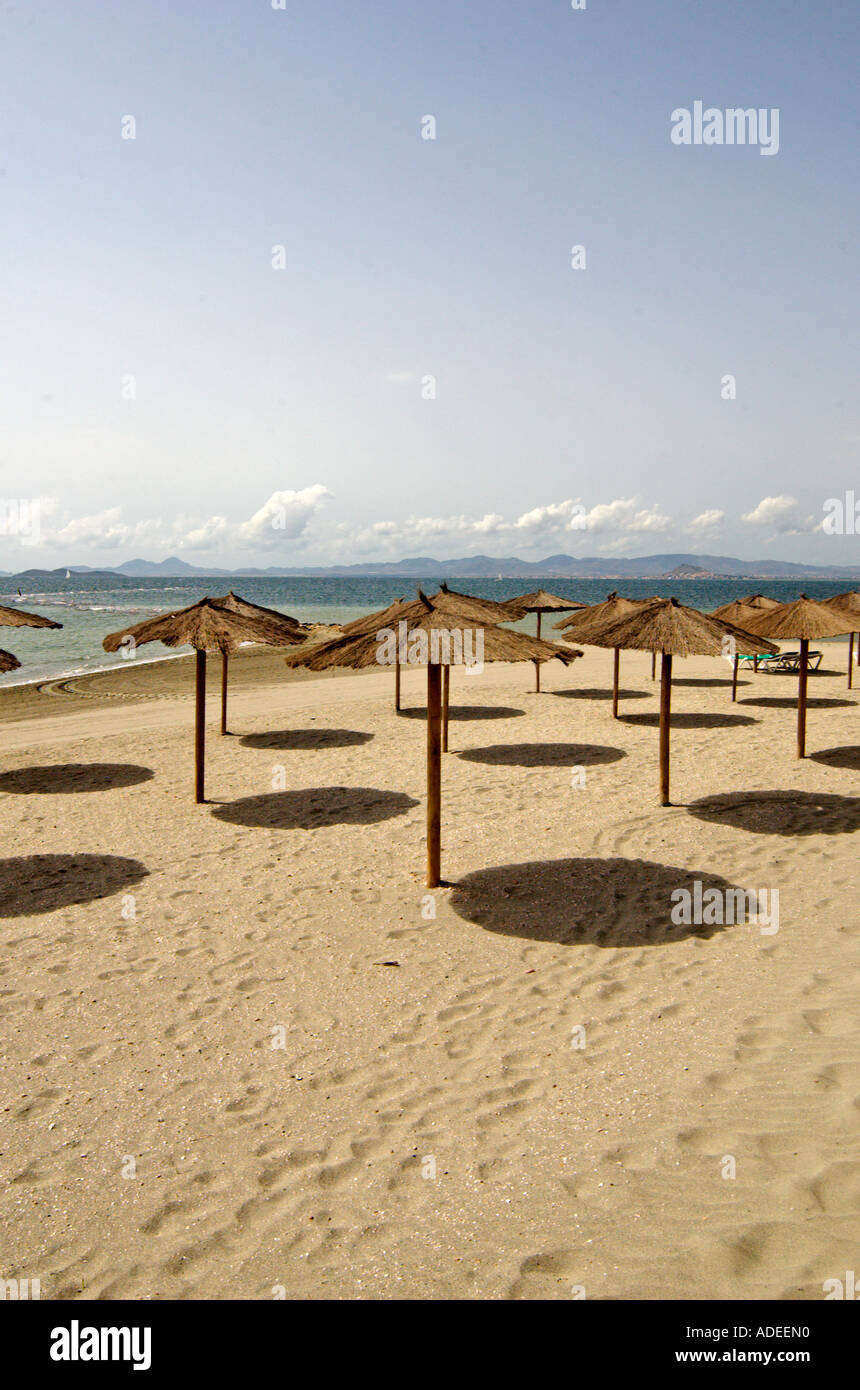 Schöner Sandstrand und Wicker Sonnenschirme in Los Alcazares Costa Calida, Süd Osten Spaniens Stockfoto