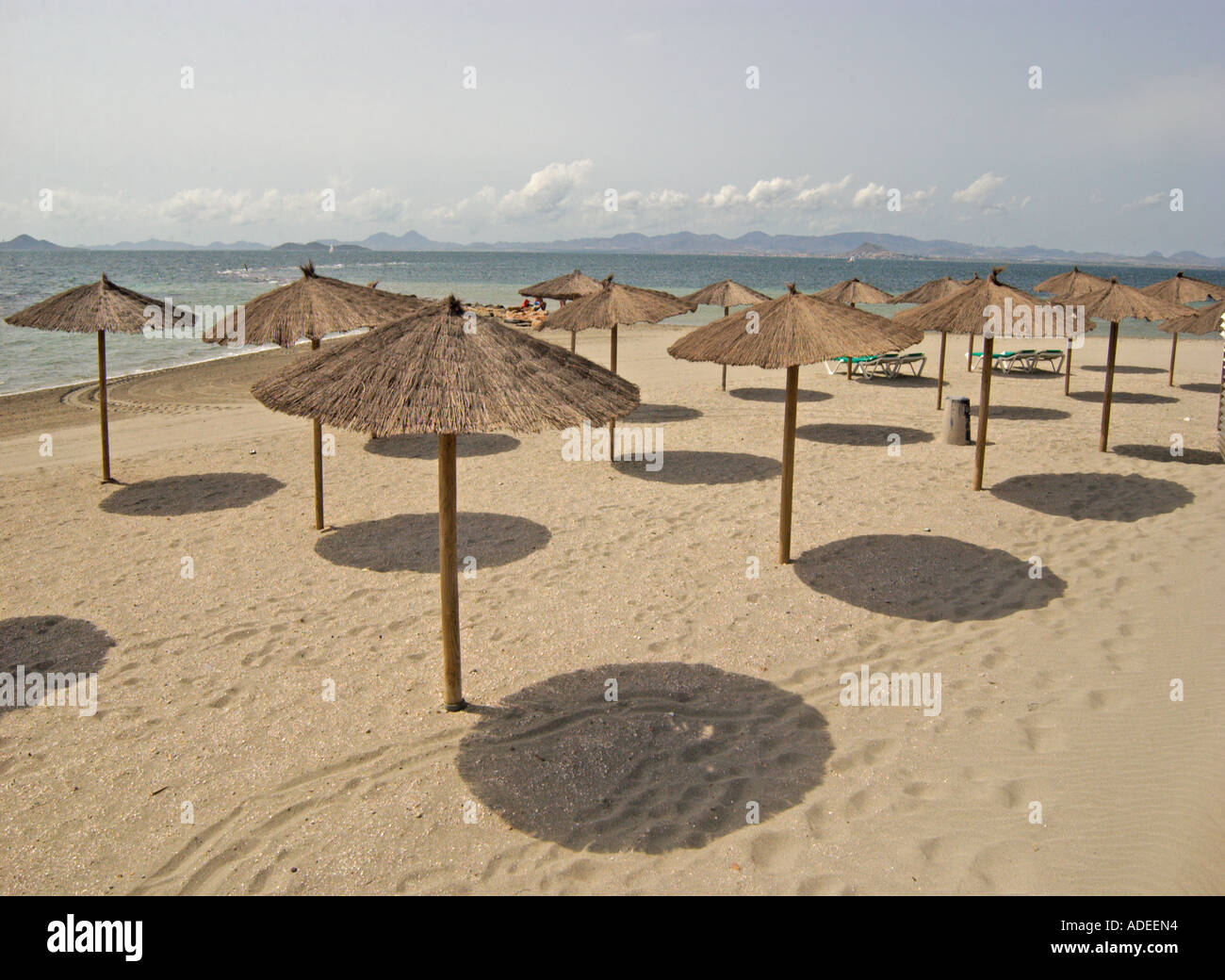 Schöner Sandstrand und Wicker Sonnenschirme in Los Alcazares Costa Calida, Süd Osten Spaniens Stockfoto