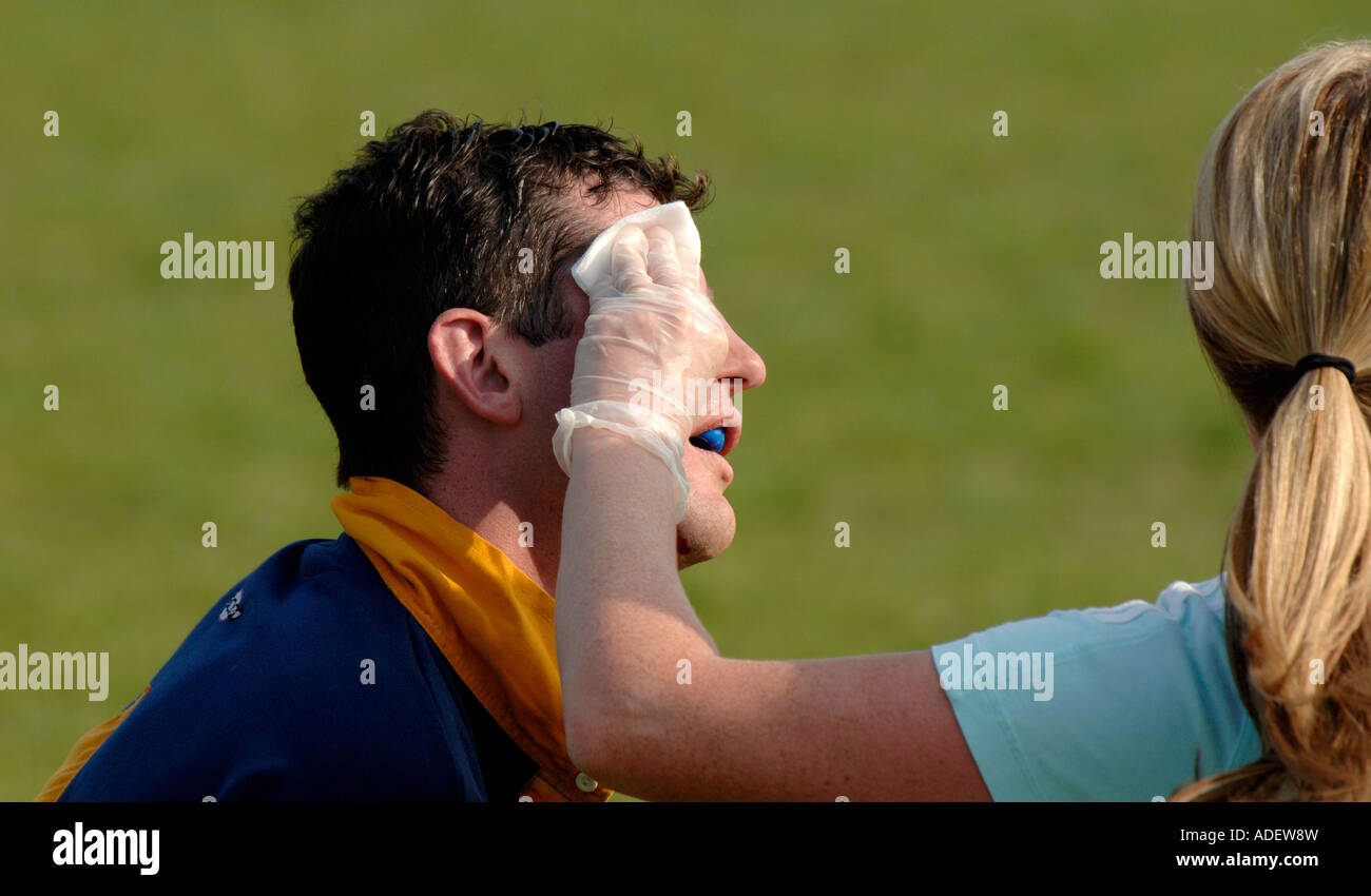 Physiotherapeut pflegt verwundeten Rugby-Spieler auf einer Touchline während eines Spiels. East Sussex, Großbritannien Stockfoto