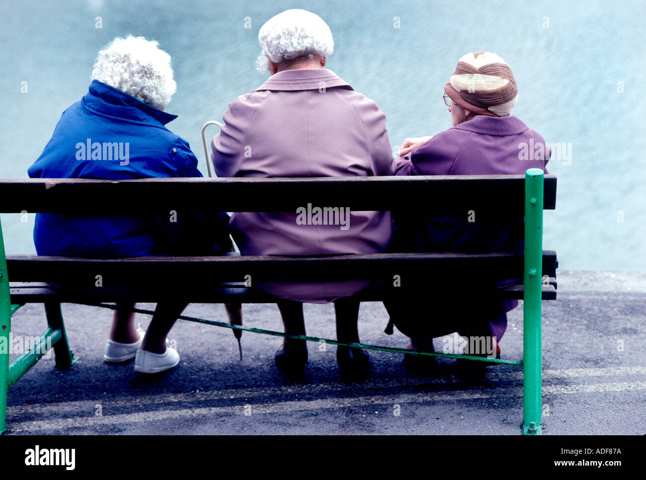 Drei glückliche pensionierten Frauen auf öffentlichen Bank entspannen. Alter und Reife Damen sitzen auf einer Parkbank geniessen Sie den Nachmittag. Silber schwarzhaarige Schönheit! Stockfoto