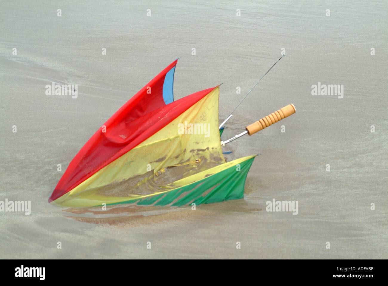 Bunte Golfschirm sank am Strand von Newton um Meer Northumberland England Vereinigtes Königreich UK Stockfoto