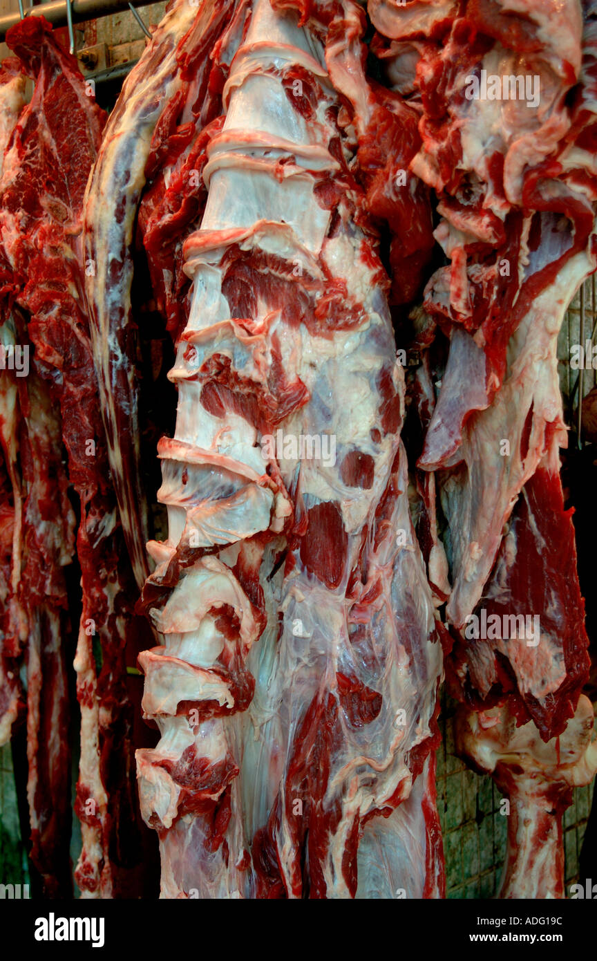 Schlachtkörper von geschlachtem Fleisch - vermutlich Rindfleisch - sind gerade so auf einem Markt in Hongkong hängen geblieben. Ohne Schutz oder Kühlerbildung. Stockfoto