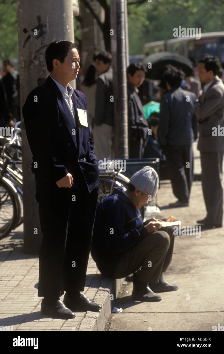 Peking China 1990er. Arbeitslose warten auf Beschäftigungsmöglichkeiten. Das handgeschriebene Schild auf seiner Jacke, das seine Fähigkeiten anpreist. 1998 HOMER SYKES Stockfoto