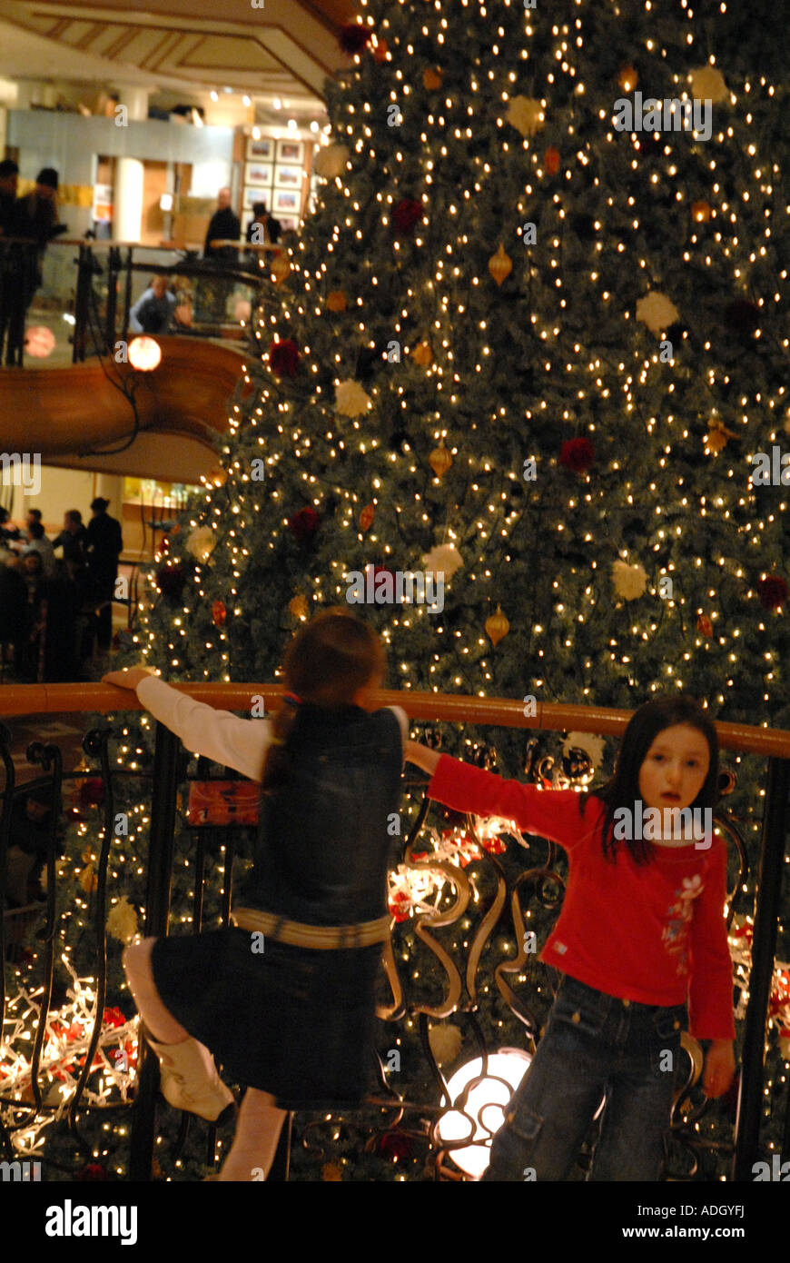 Junge Mädchen hängen am Geländer vor Weihnachtsbaum am Princes Square Shopping Centre, Glasgow. Schottland. Dezember 06 Stockfoto