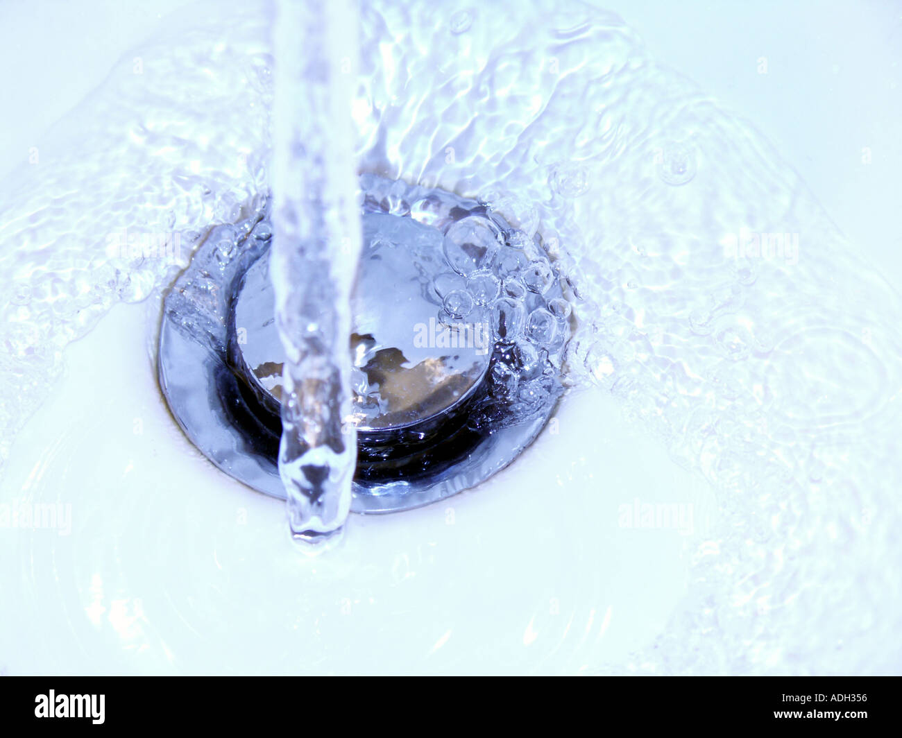 Wasser läuft nach unten ein Dübelloch schließen Stockfoto