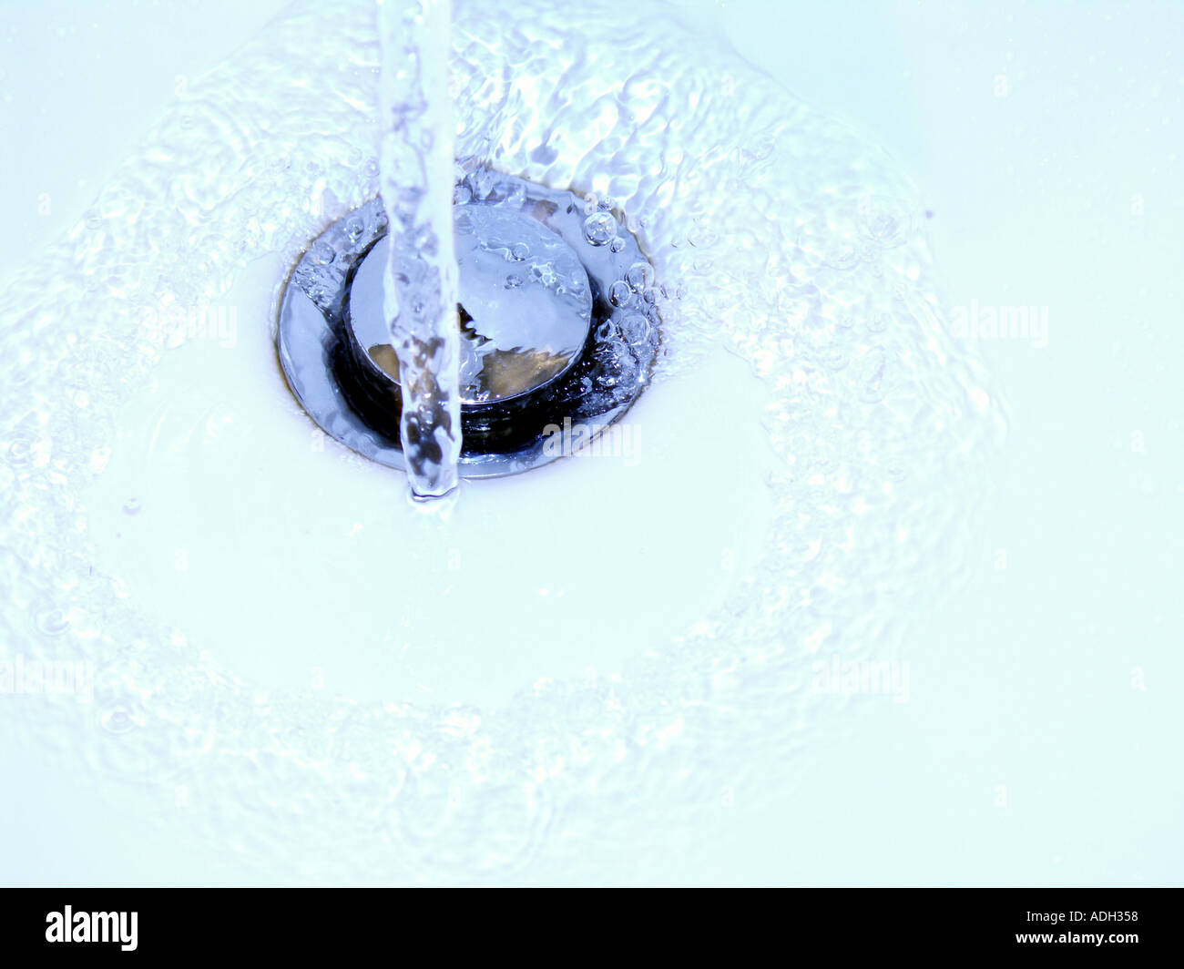 Wasser läuft nach unten ein Dübelloch Stockfoto