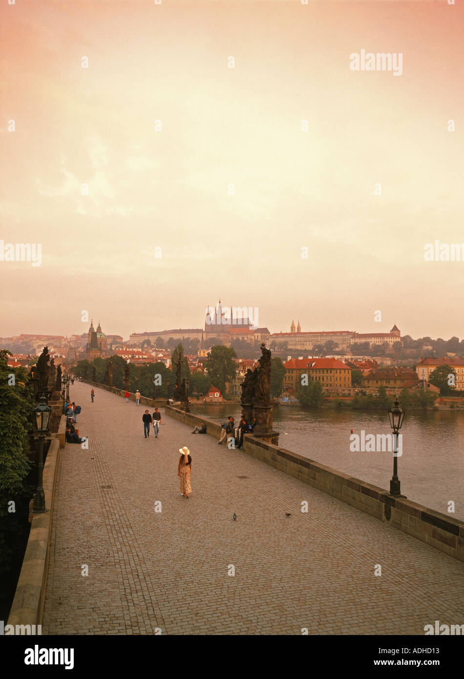 Frau allein zu Fuß über die Karlsbrücke bei Sonnenaufgang in Prag Stockfoto