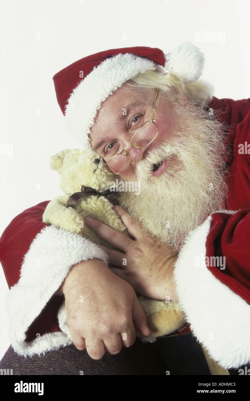 Porträt von Santa Claus umarmt einen Teddybär Stockfoto