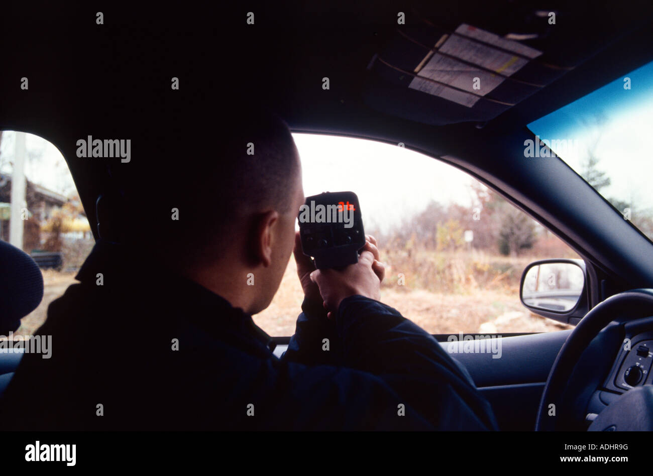 Polizist in Kreuzer mit einem handheld Laser messen die Geschwindigkeit der Autofahrer sitzen. Kansas City, MO, PD, USA. Stockfoto