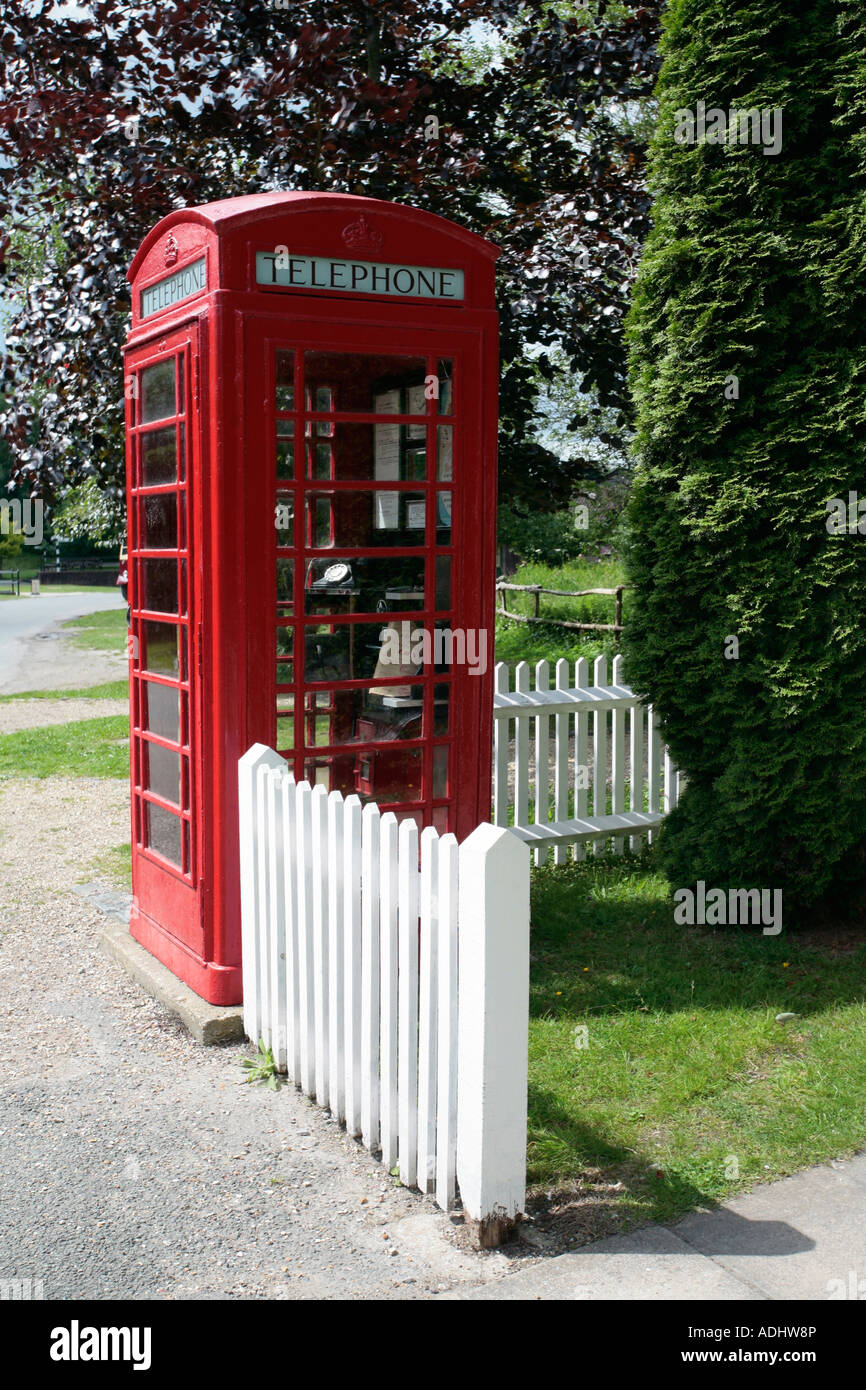 Traditionelles rotes englisches öffentliches Telefonfeld neben weißem Zaun im Amberley Working Museum, West Sussex Stockfoto