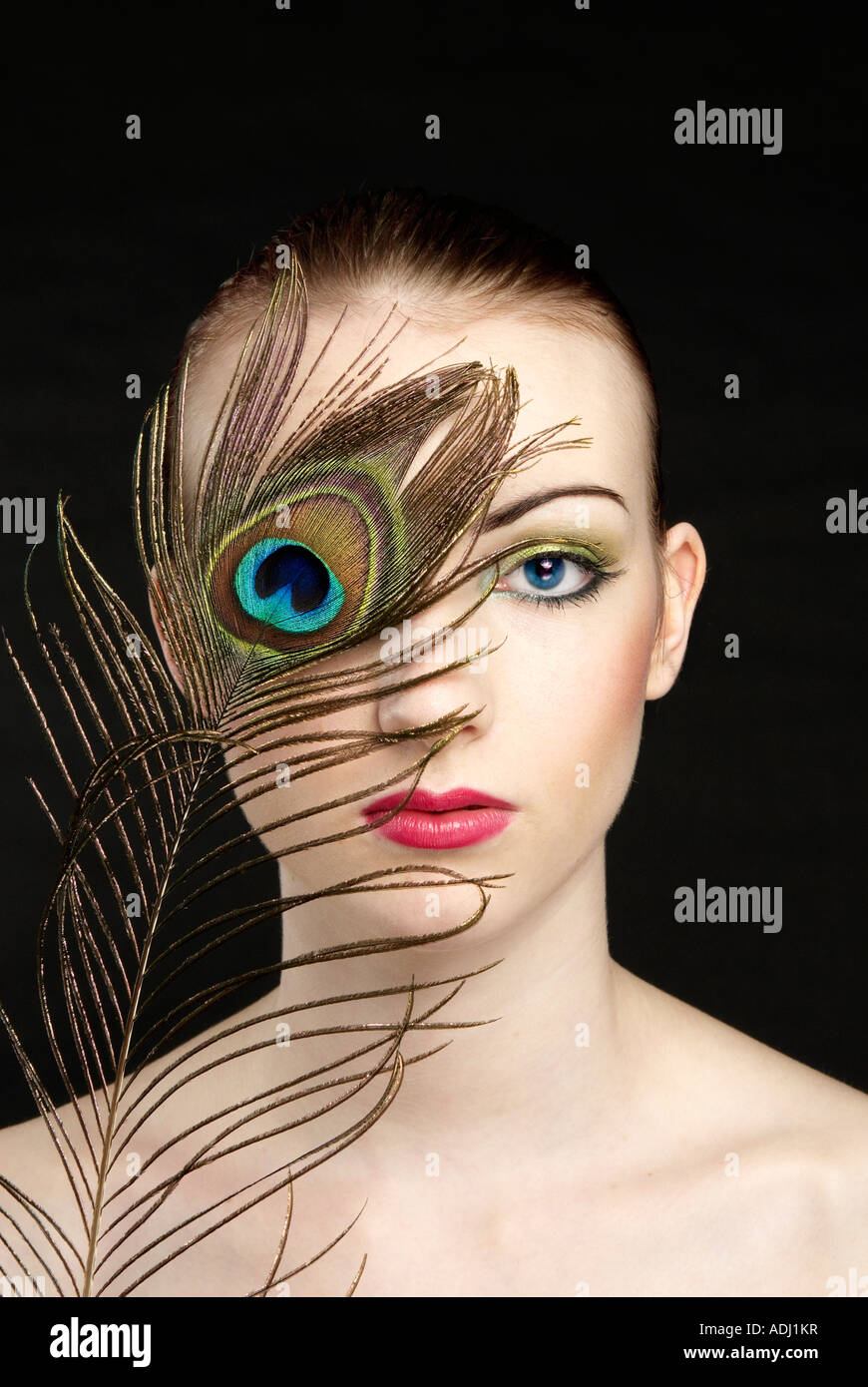 Frau mit blauen Augen mit Pfauenfedern Stockfoto
