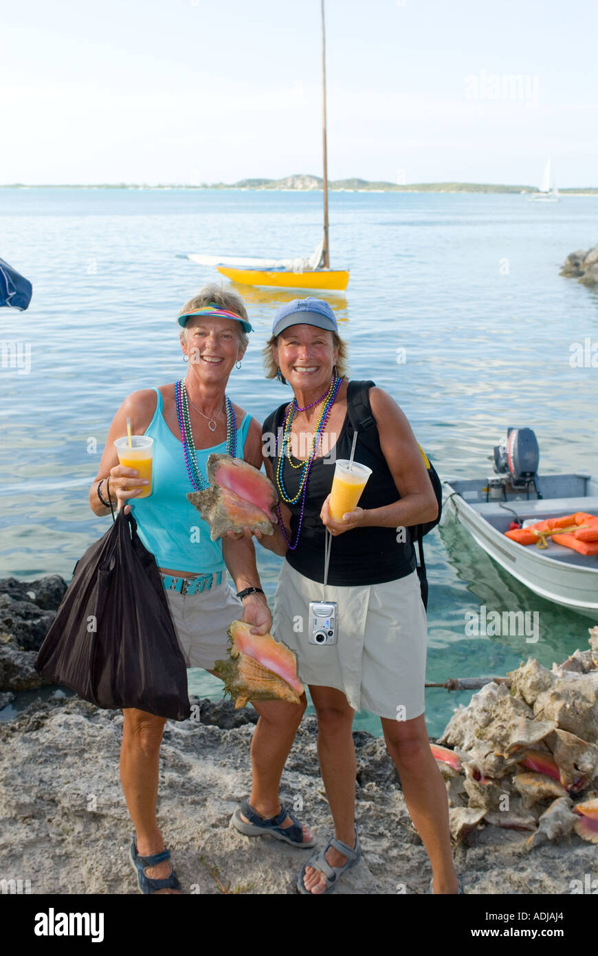 GREAT EXUMA BAHAMA GEORGE TOWN Frauen Touristen hält Muscheln und tropische Drinks in Elizabeth Bay Harbour Stockfoto