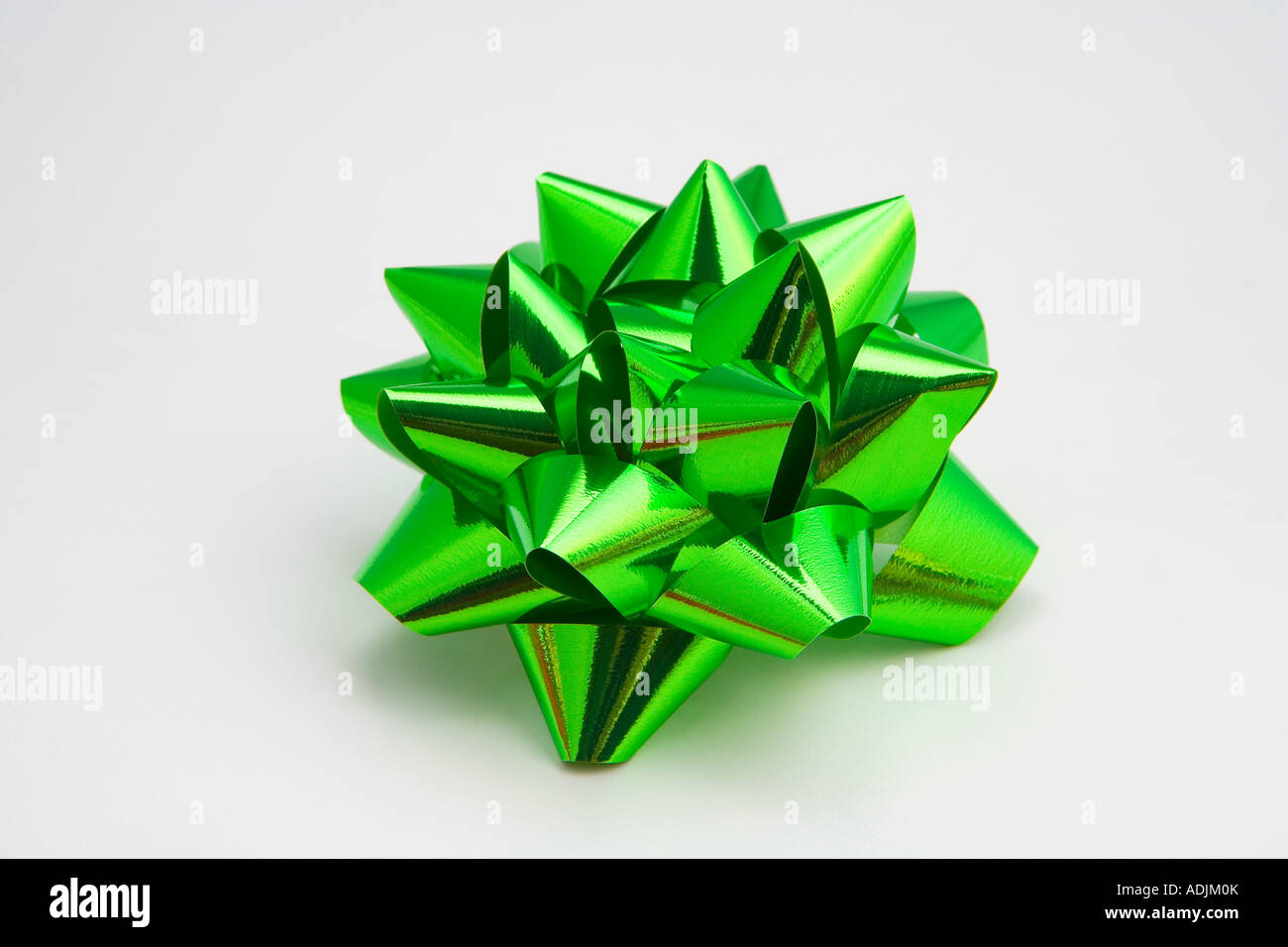 Nahaufnahme von einem glänzenden grün Weihnachtsgeschenk Bogen auf weißem Hintergrund Studioportrait Stockfoto
