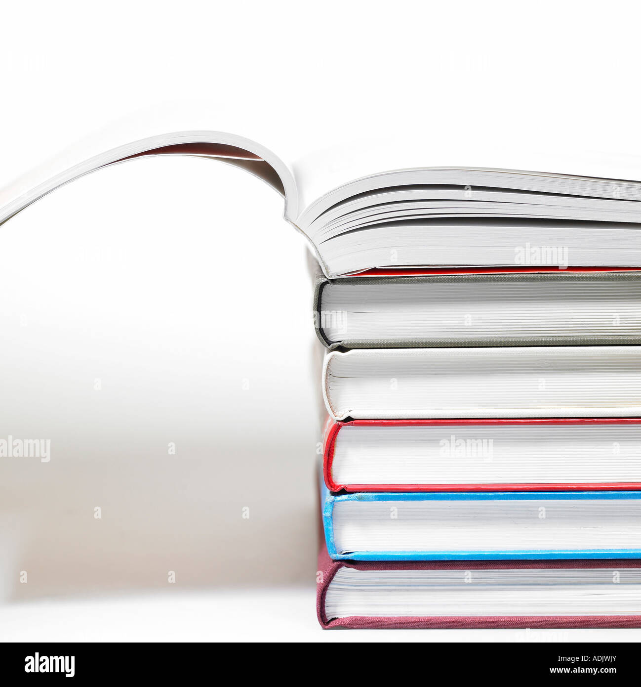 Ein aufgeschlagenes Buch über die gestapelten Bücher Stockfoto