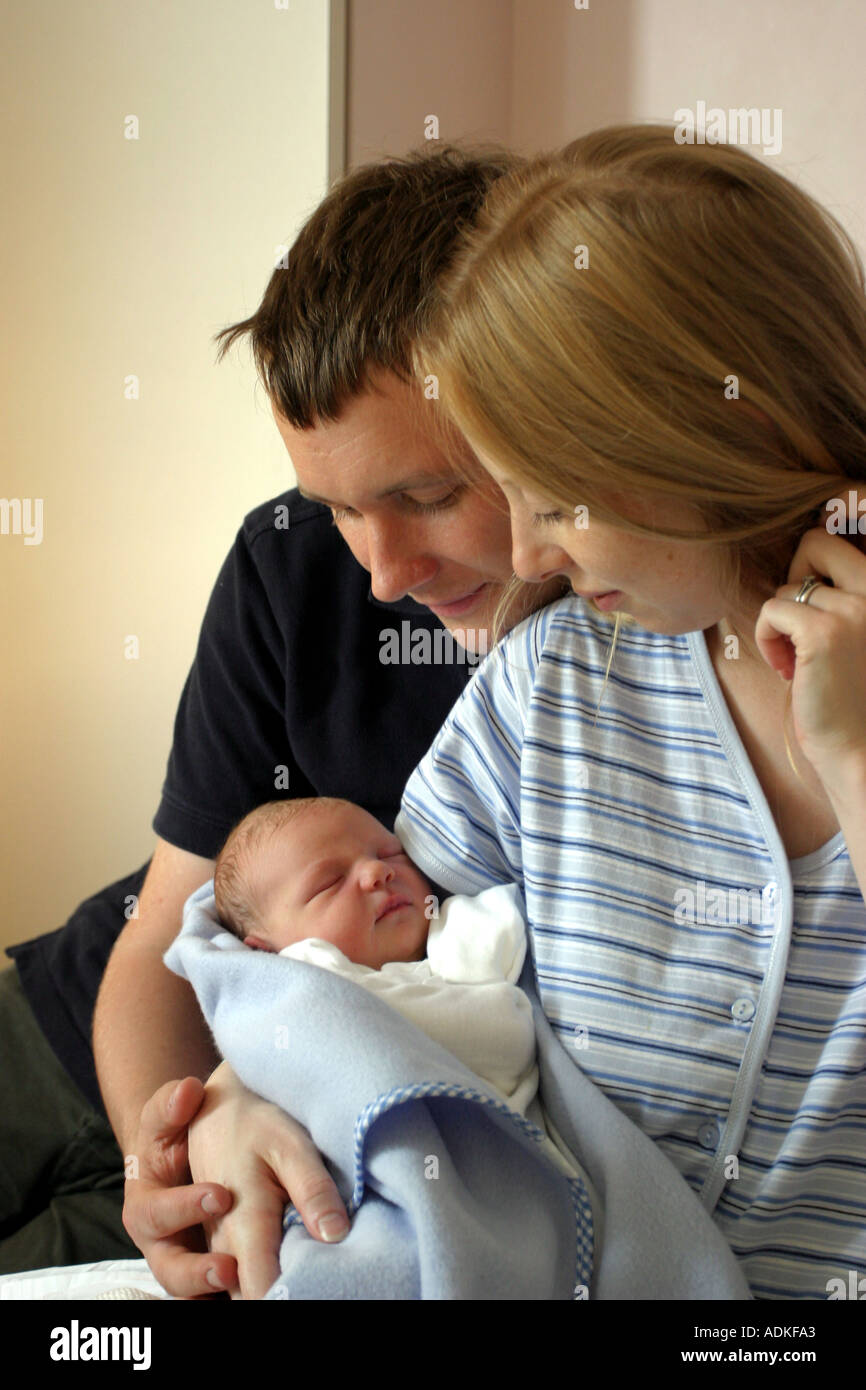 Stolze Eltern, halten ihre schlafenden neugeborenen Babys in eine Decke gehüllt. Stockfoto