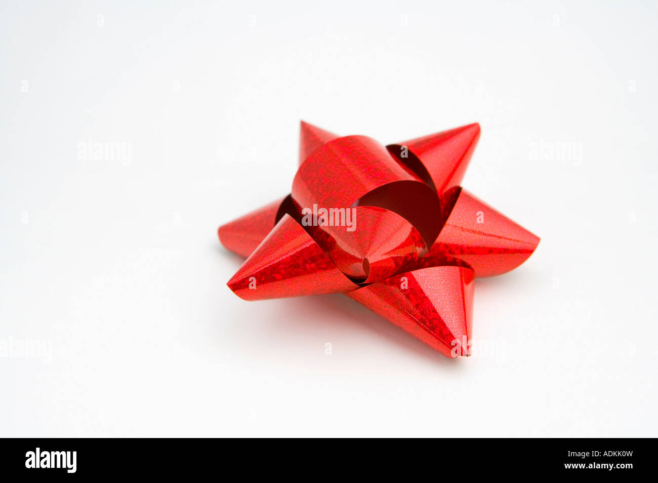 Nahaufnahme von einem leuchtend roten Weihnachtsgeschenk Bogen auf weißem Hintergrund Studioportrait Stockfoto