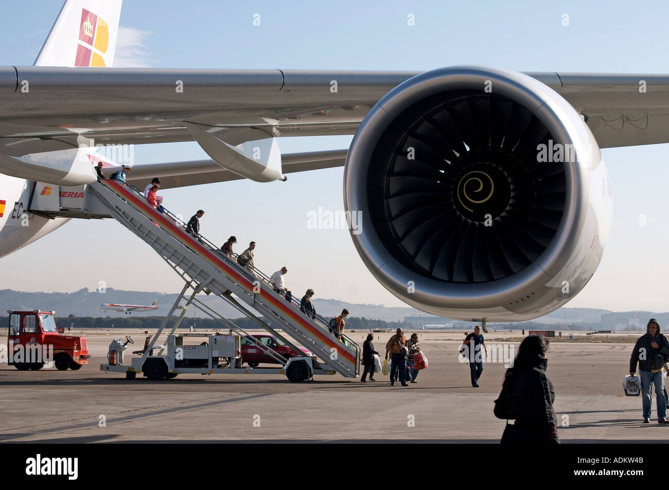 Passagiere, die ein Iberia Airbus am Flughafen Madrid mit Rolls-Royce Motor Stockfoto