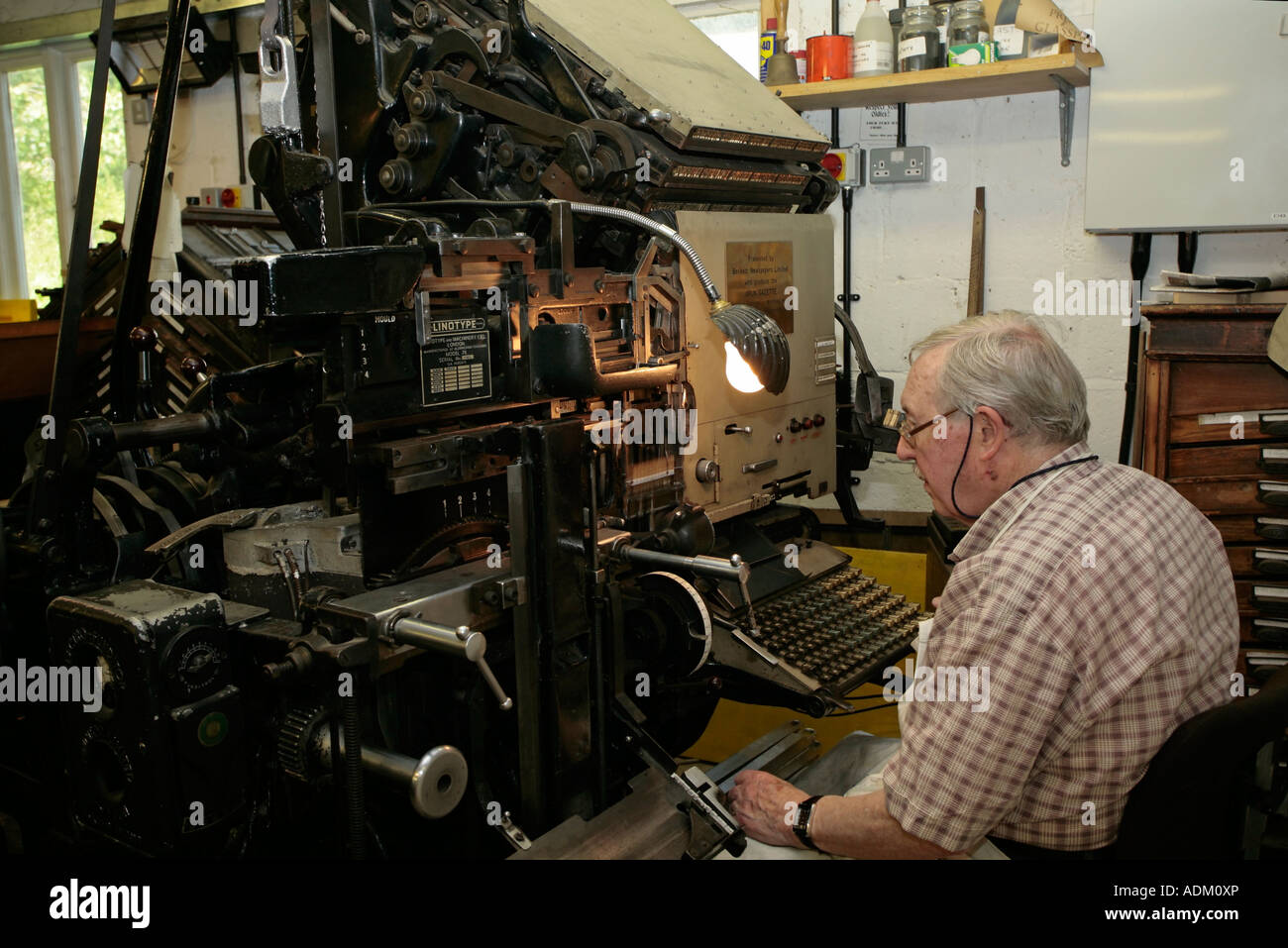 Mann, der eine Linotype 78-Druckmaschine im Amberley Working Museum, West Sussex, betreibt Stockfoto