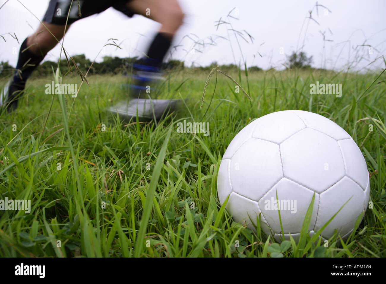 Fußball Spieler laufen, einen Fußball zu treten Stockfoto