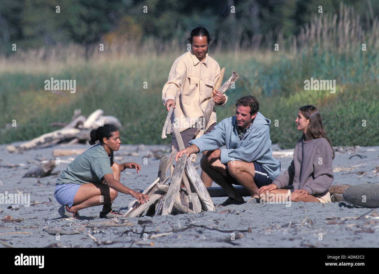 Freunde bauen ein Lagerfeuer am Strand Stockfoto