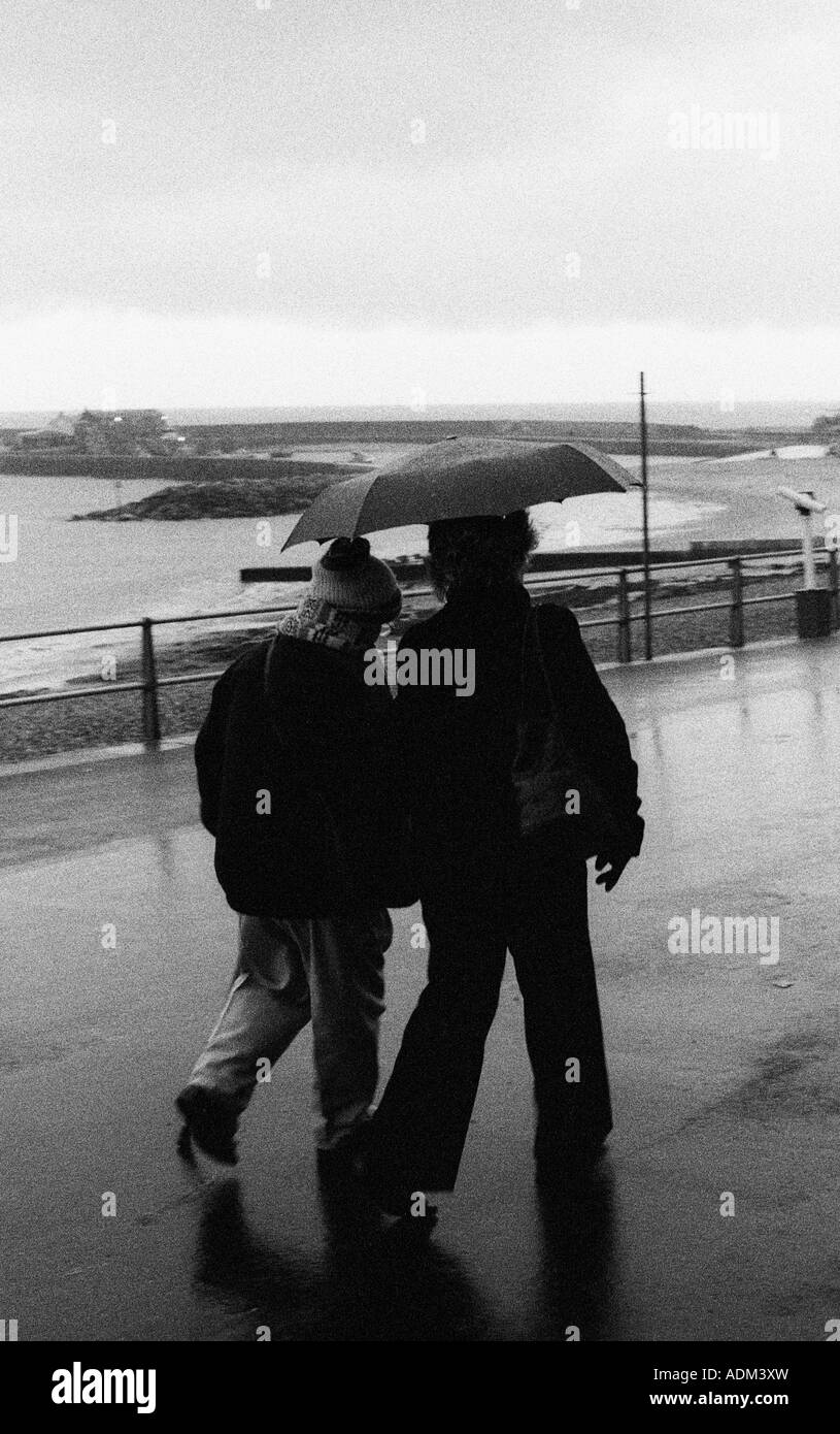 Paar im Regen am Meer Stockfoto