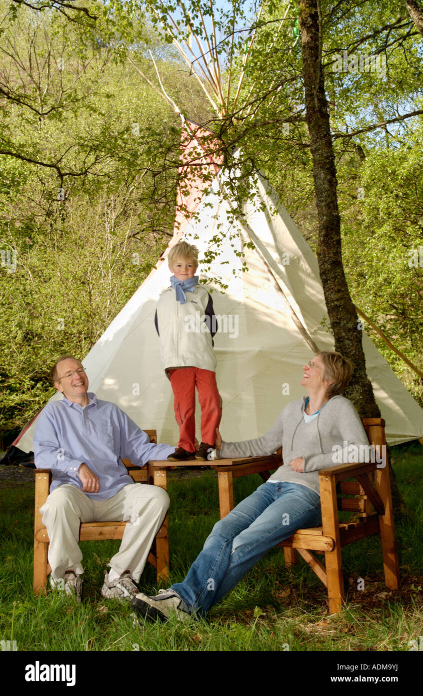 Familiengruppe auf Campingurlaub im Zelt am Spezialist Tipi Campingplatz am Bauernhof in Mid Wales UK Stockfoto