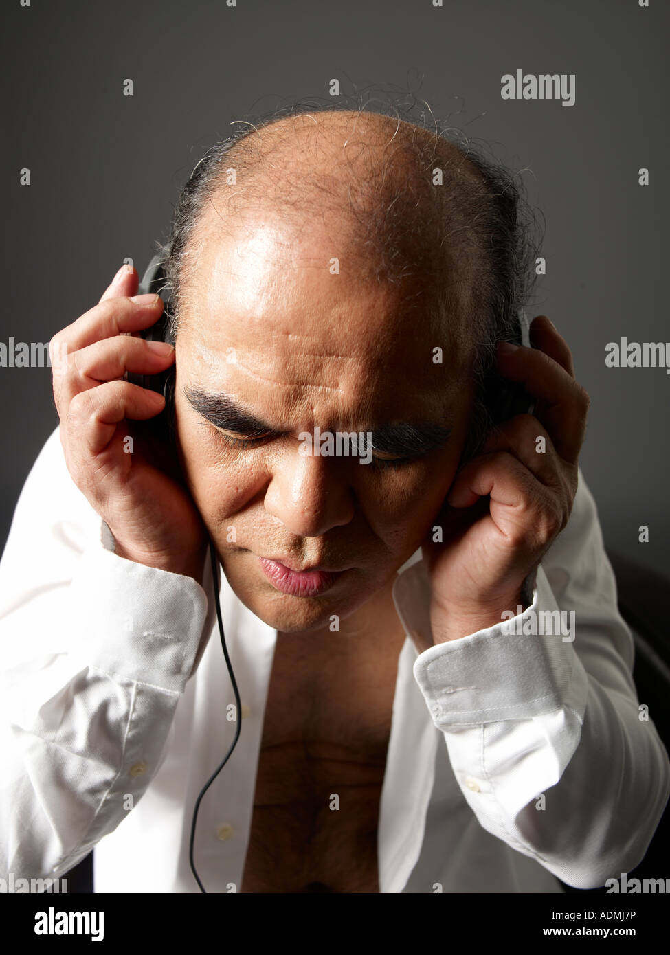 Reifer Mann trägt ein weißes Hemd mit Kopfhörer Stockfoto