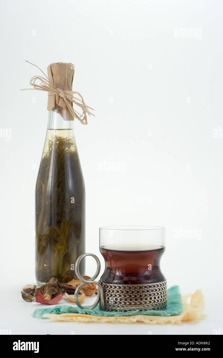 Dekorative Flasche mit Dill und Öl und Tasse Tee ruht auf blauen und gelben Stoffservietten Stockfoto