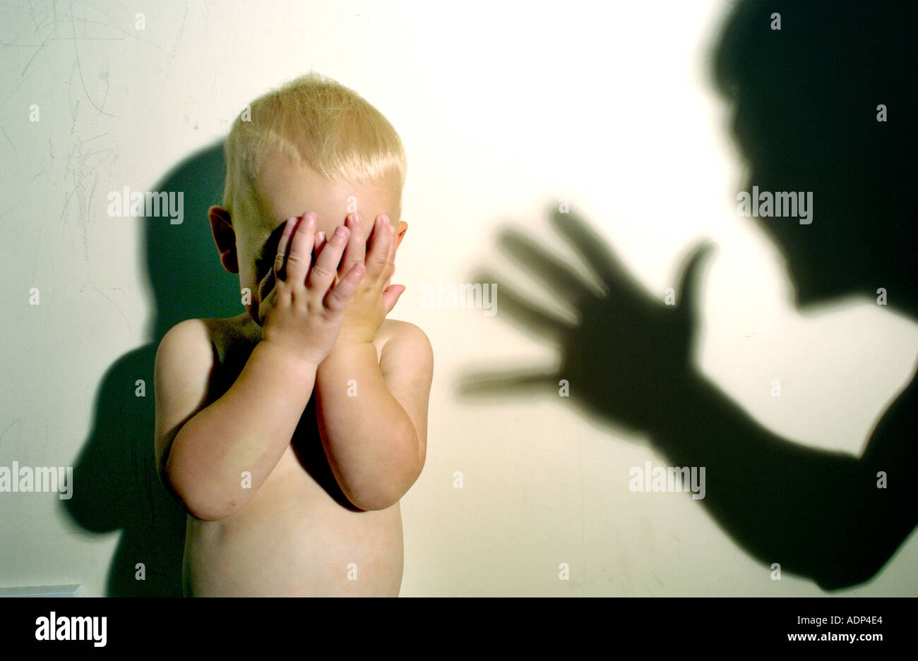 Erschrocken weinerlich Kind bedroht mit Missbrauch mit Schatten der Täter drohend über ihn Stockfoto