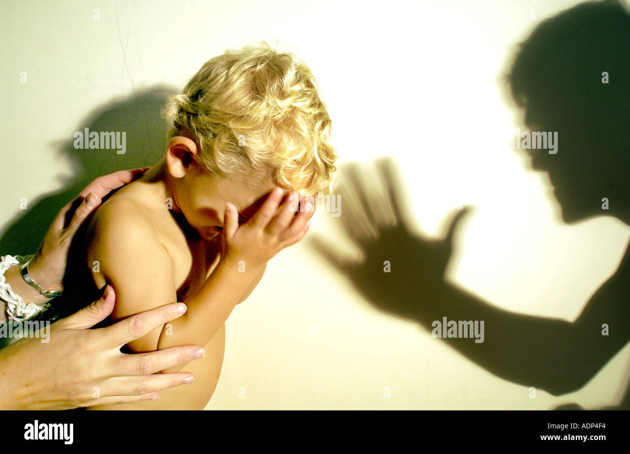 Erschrocken weinerlich Kind bedroht mit Missbrauch von weiblichen Händen getröstet und von einem Mann bedroht Stockfoto