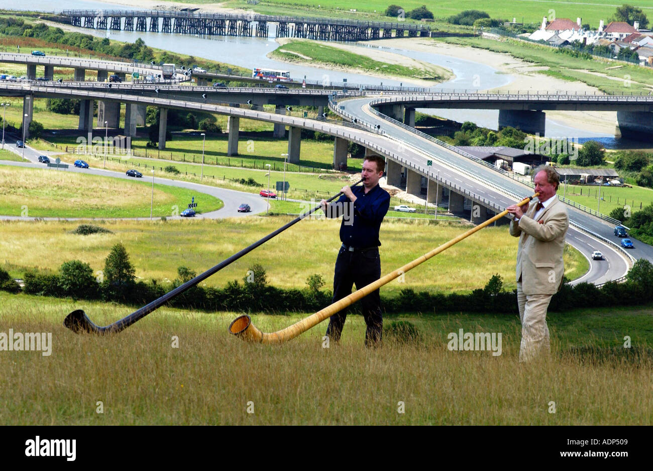 Zwei Männer spielen Alphorn oder Alphorn die seltsame Schweizer Musikinstrument. Stockfoto