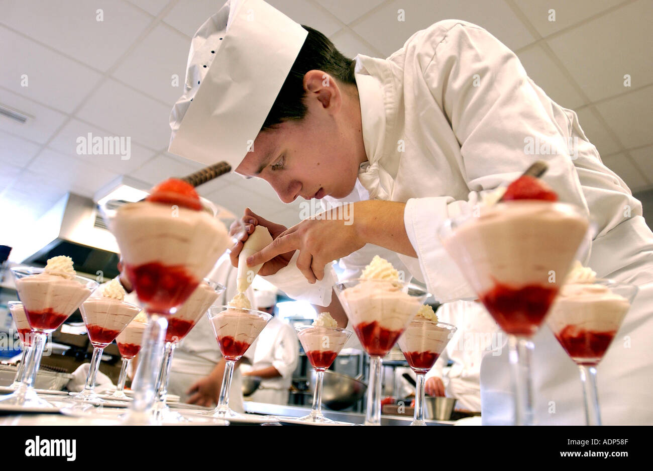 Ein 16-jährige Catering und Hospitality Student schmückt Obst Kleinigkeiten Stockfoto