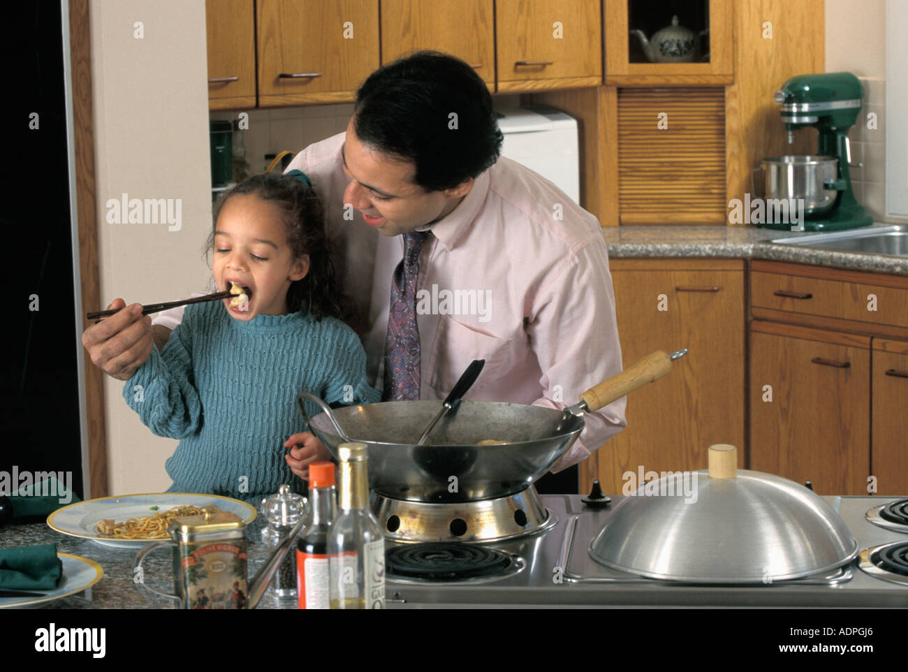 Latino-Vater und Tochter Kochen unter Rühren braten in Küche Stockfoto