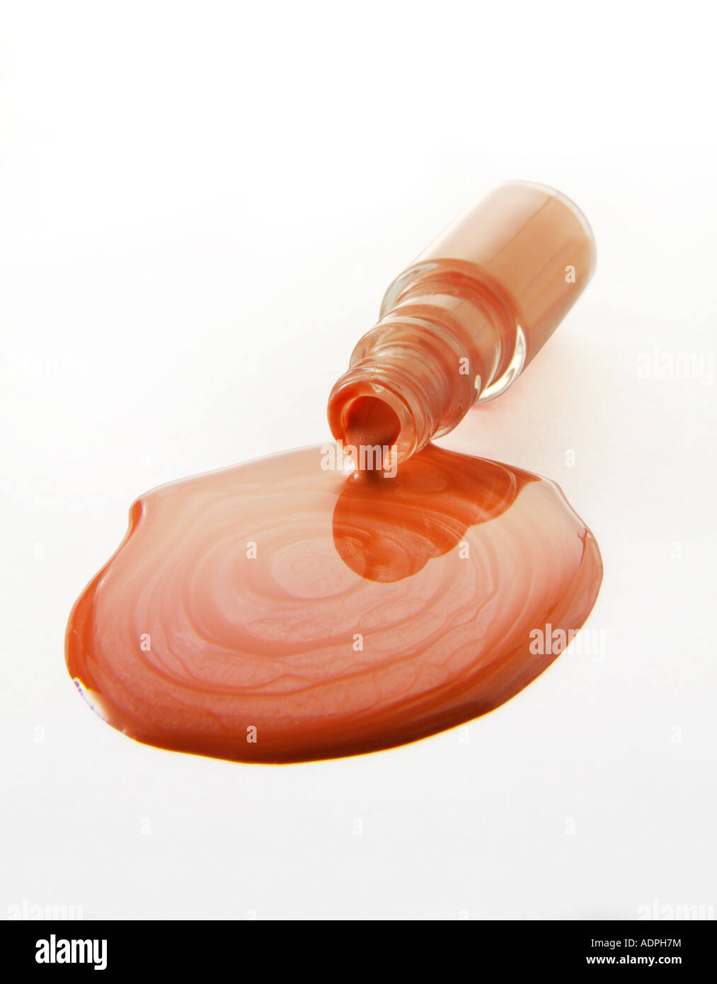 Nagellack-Flasche, die gefallen ist, über einen Pool von Nagellack zu verschütten Stockfoto