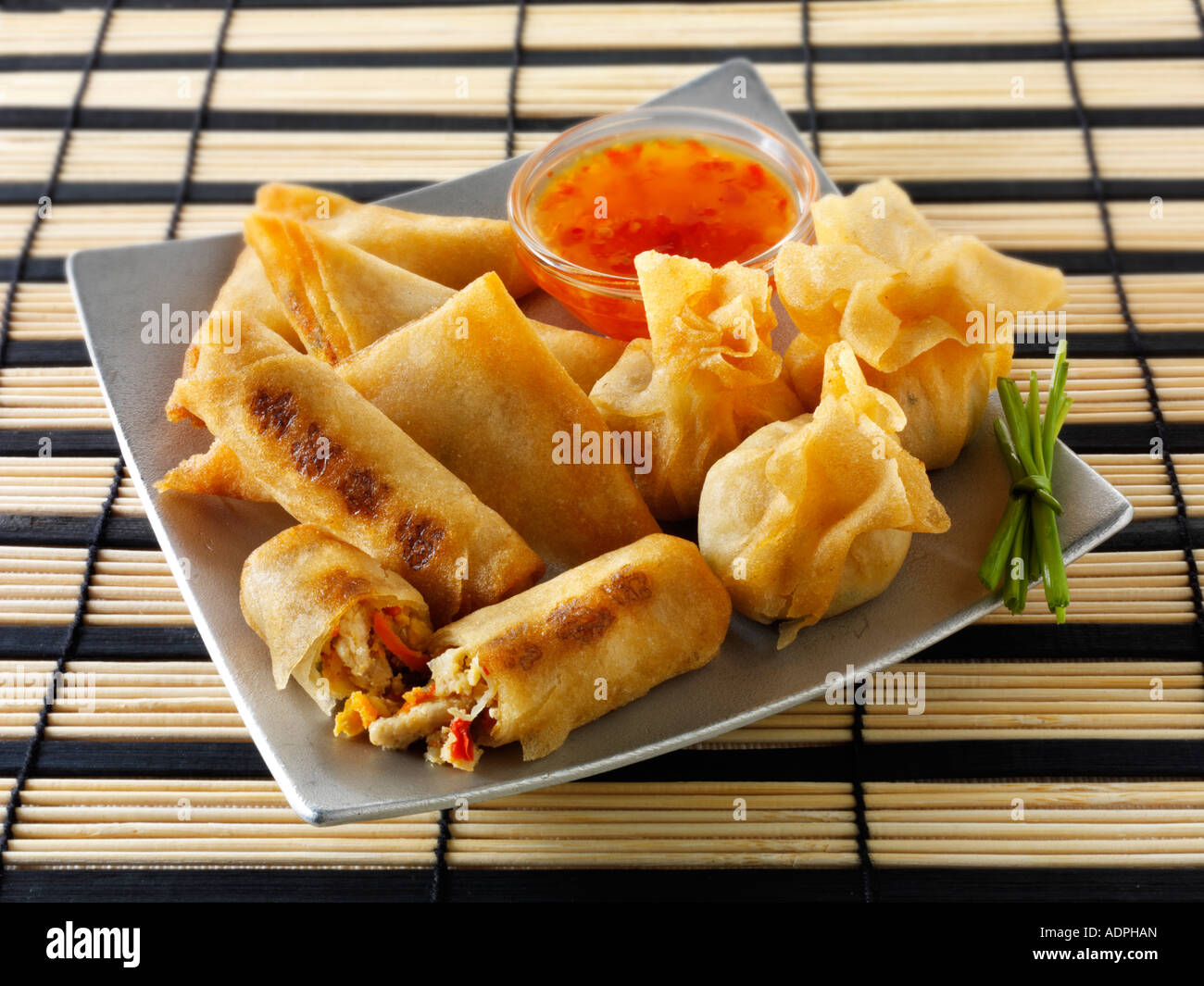 Orientalische Auswahl mit dim sum Frühlingsrollen mit Huhn Gemüse und Gemüseerzeugnisse Samosas mit einem Chili Soße Stockfoto