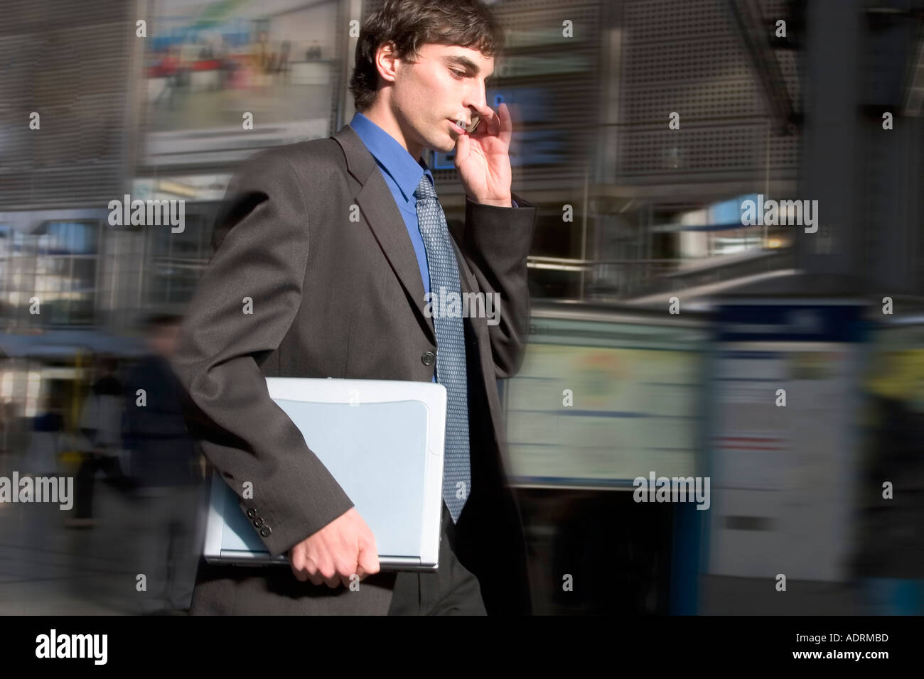 Geschäftsmann mit Handy und Laptop eilt über ein terminal Stockfoto