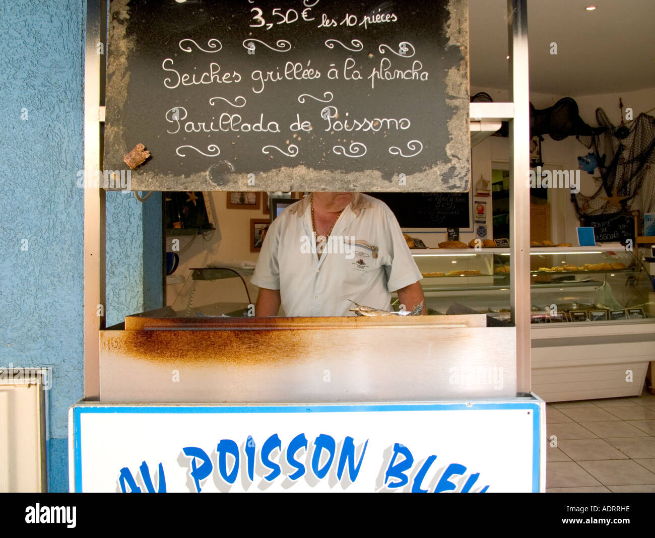 eine verkürzte Ansicht eines Mannes Grillen Sardinen in einer Snackbar im Süden von Frankreich Stockfoto