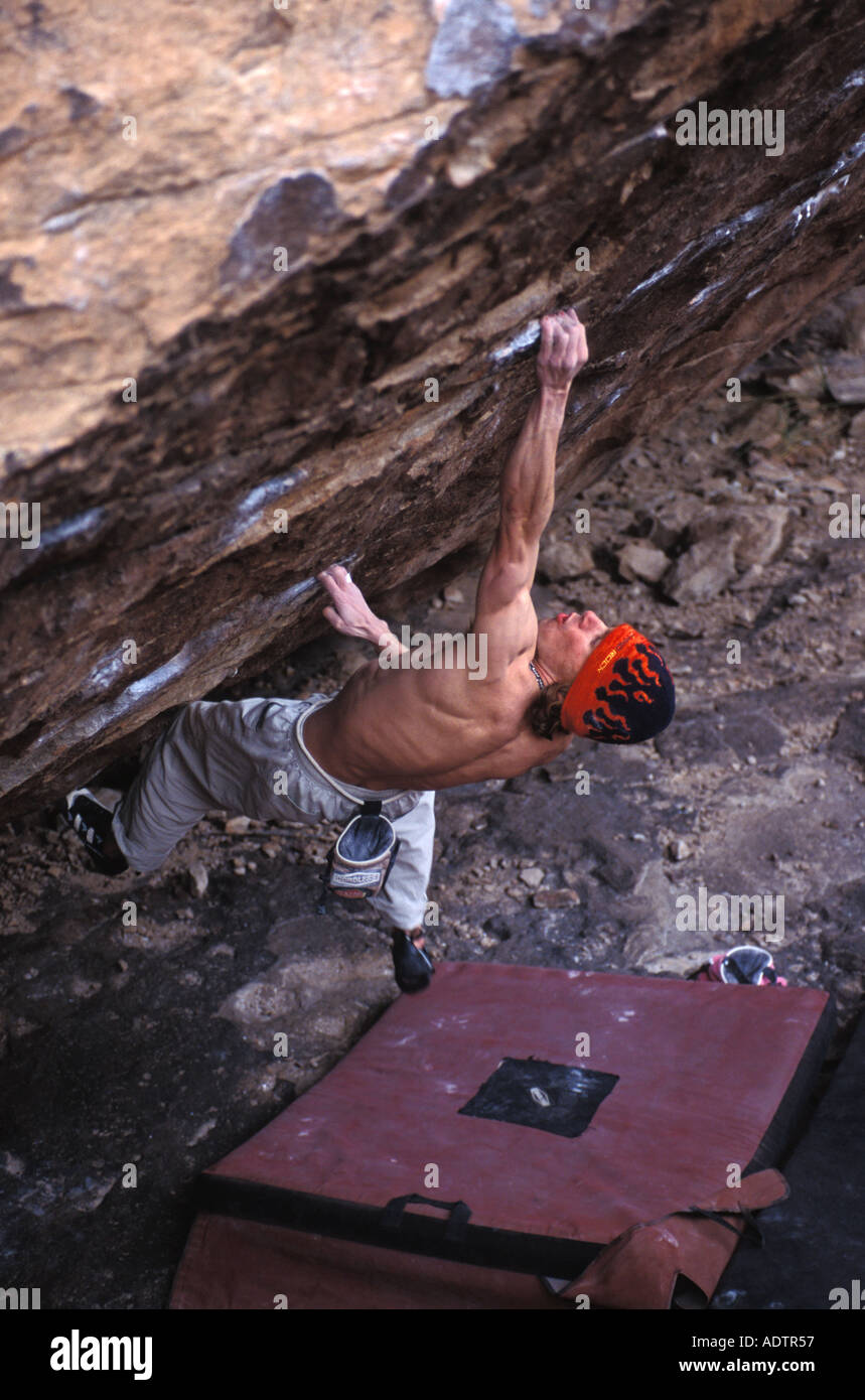 Männliche Kletterer Klettern auf einem steilen Felsen. Stockfoto