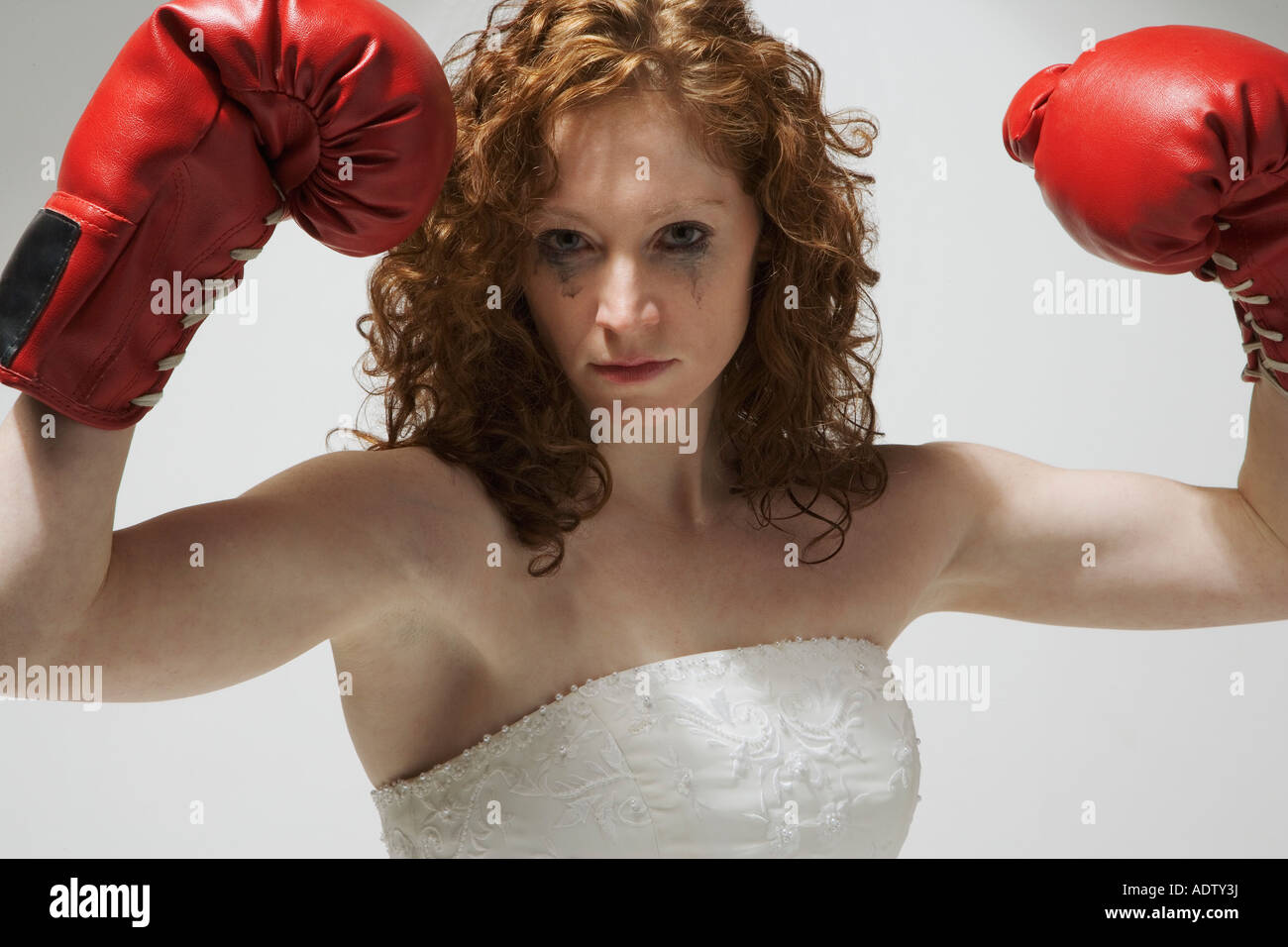 Frau im Hochzeitskleid mit Boxhandschuhen Stockfoto