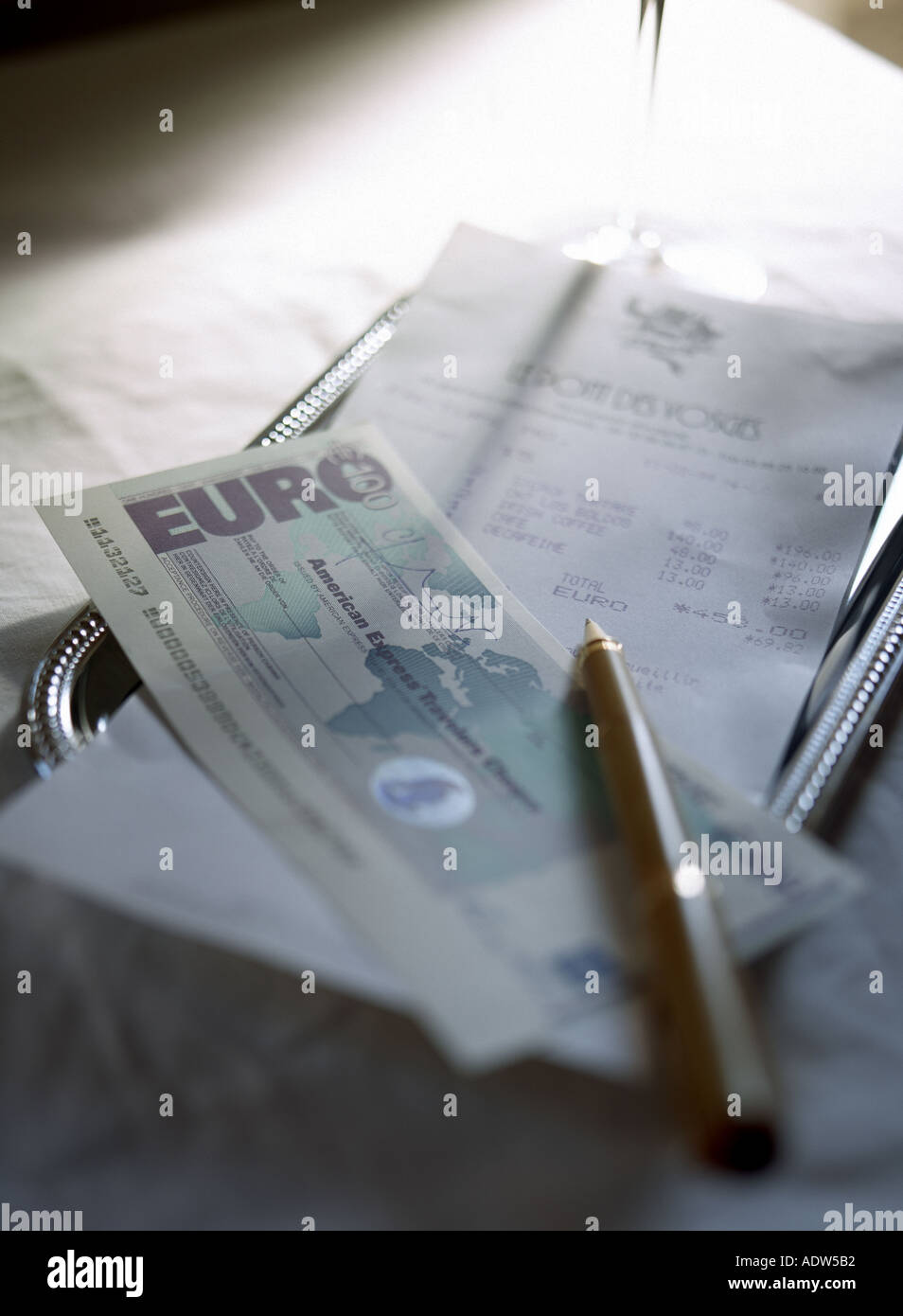 TRINKGELD-TABLETT IM RESTAURANT MIT KASSENQUITTUNG FÜR GÄSTE-SCHECK UND EURO TRAVELLERS SCHECK Stockfoto