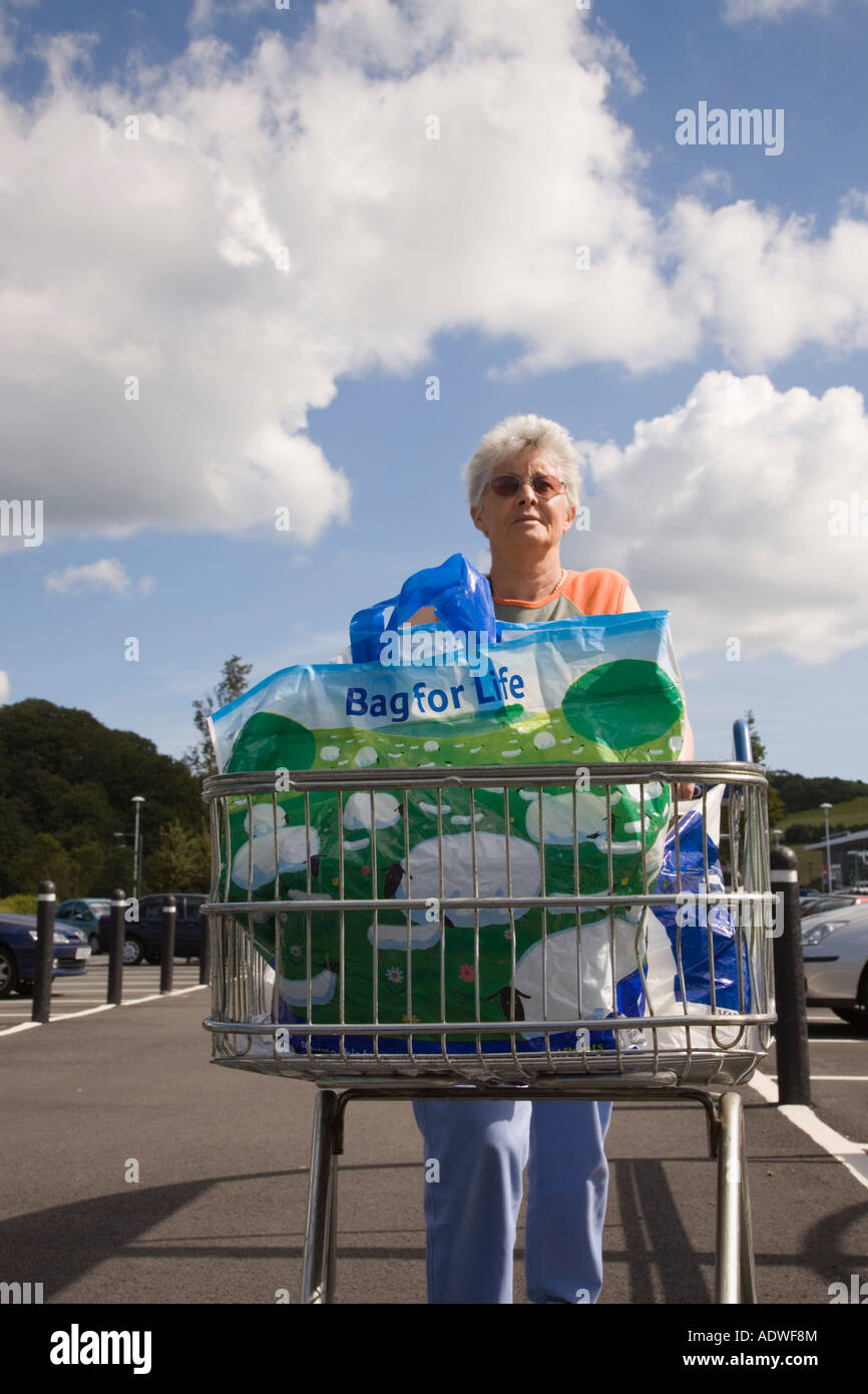 Ältere Dame schieben Einkaufswagen Kunststoff Tragetasche für Life UK Stockfoto