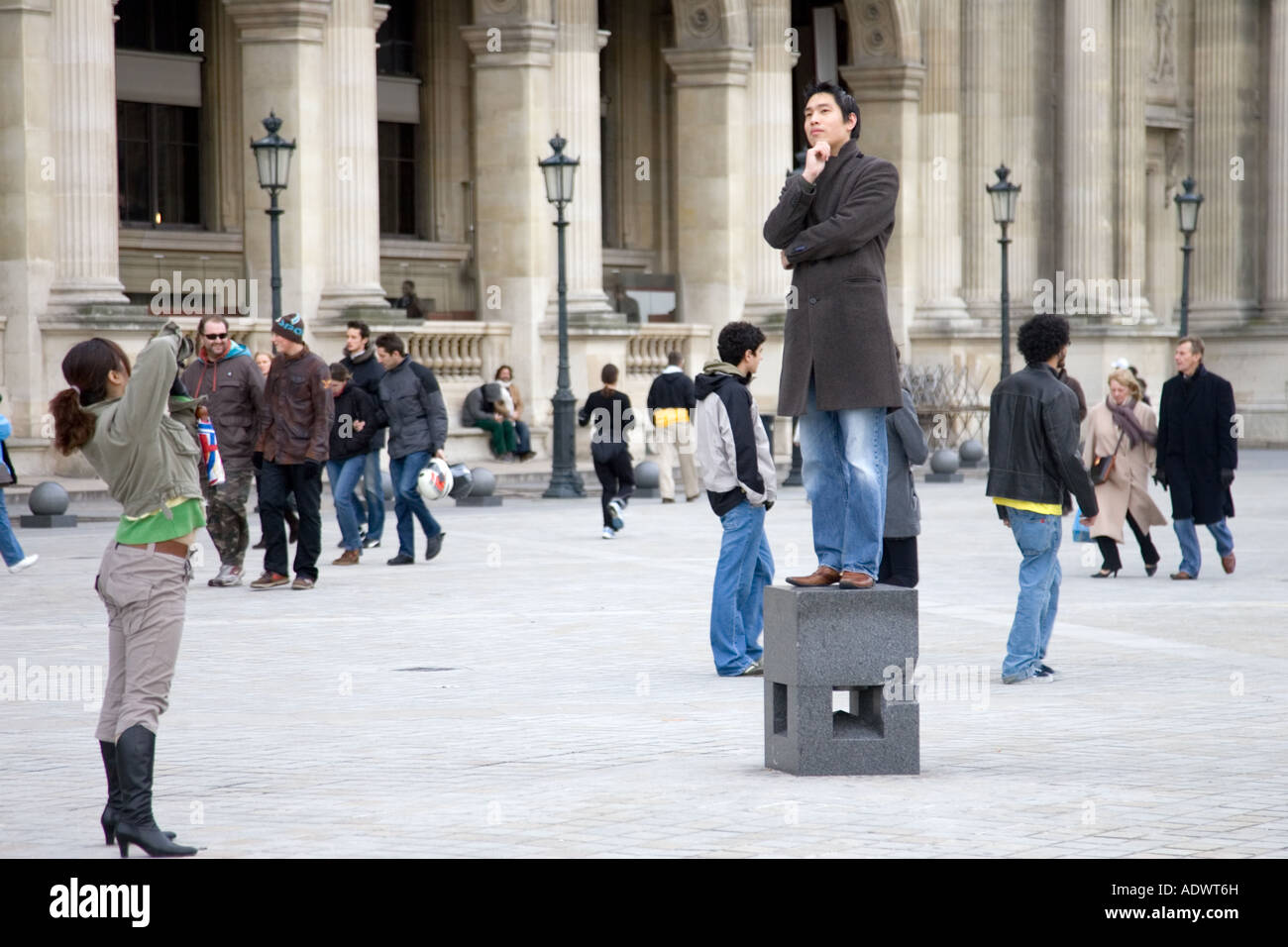 Tourist hat seine Foto balancieren auf posiert Sockel außerhalb der Louvre Museum in Paris Frankreich Stockfoto