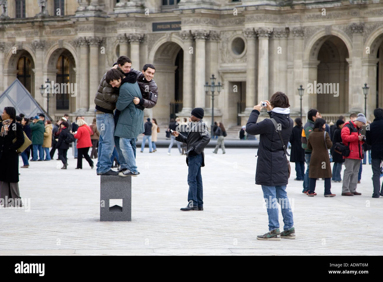 Junge Touristen Spaß versuchen, balance auf posiert Sockel vor dem Louvre Museum Central Paris Frankreich Stockfoto