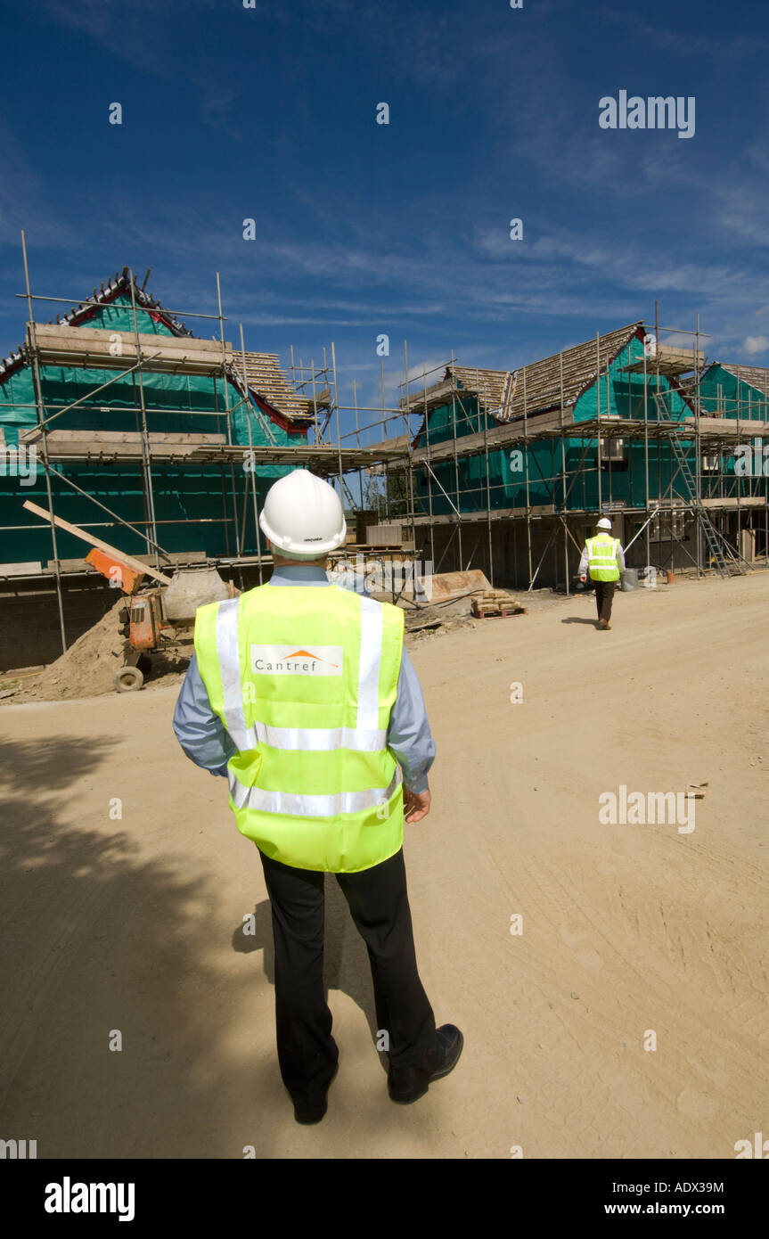 Offizier der Cantref Wohnungsbaugesellschaft Inspektion Neubau am Newport Pembrokeshire Wales eine Warnweste tragen Stockfoto